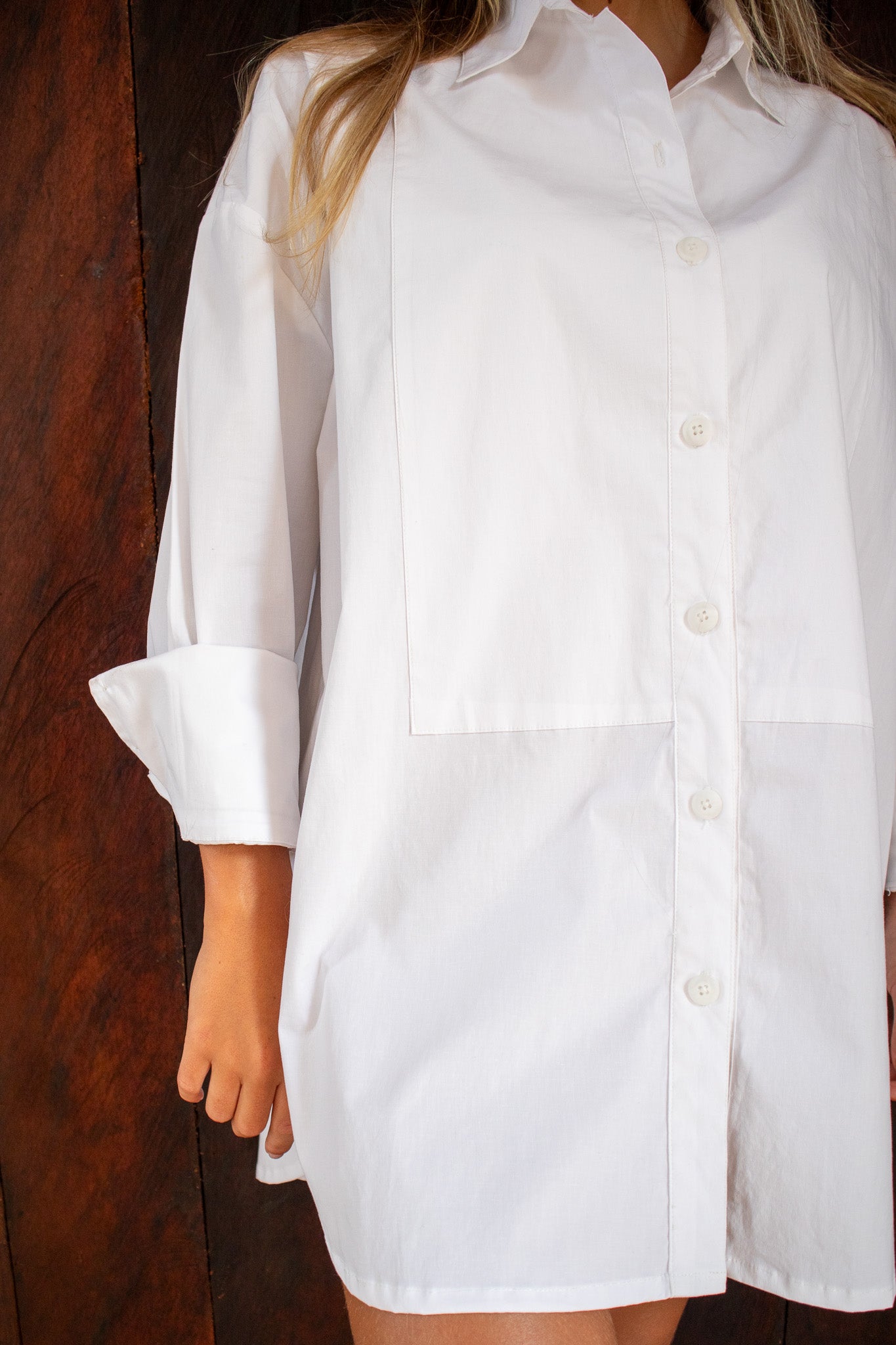 Close-up of The Boyfriend Tux Shirt in white, showcasing chest pockets, curved hem, and front buttons.