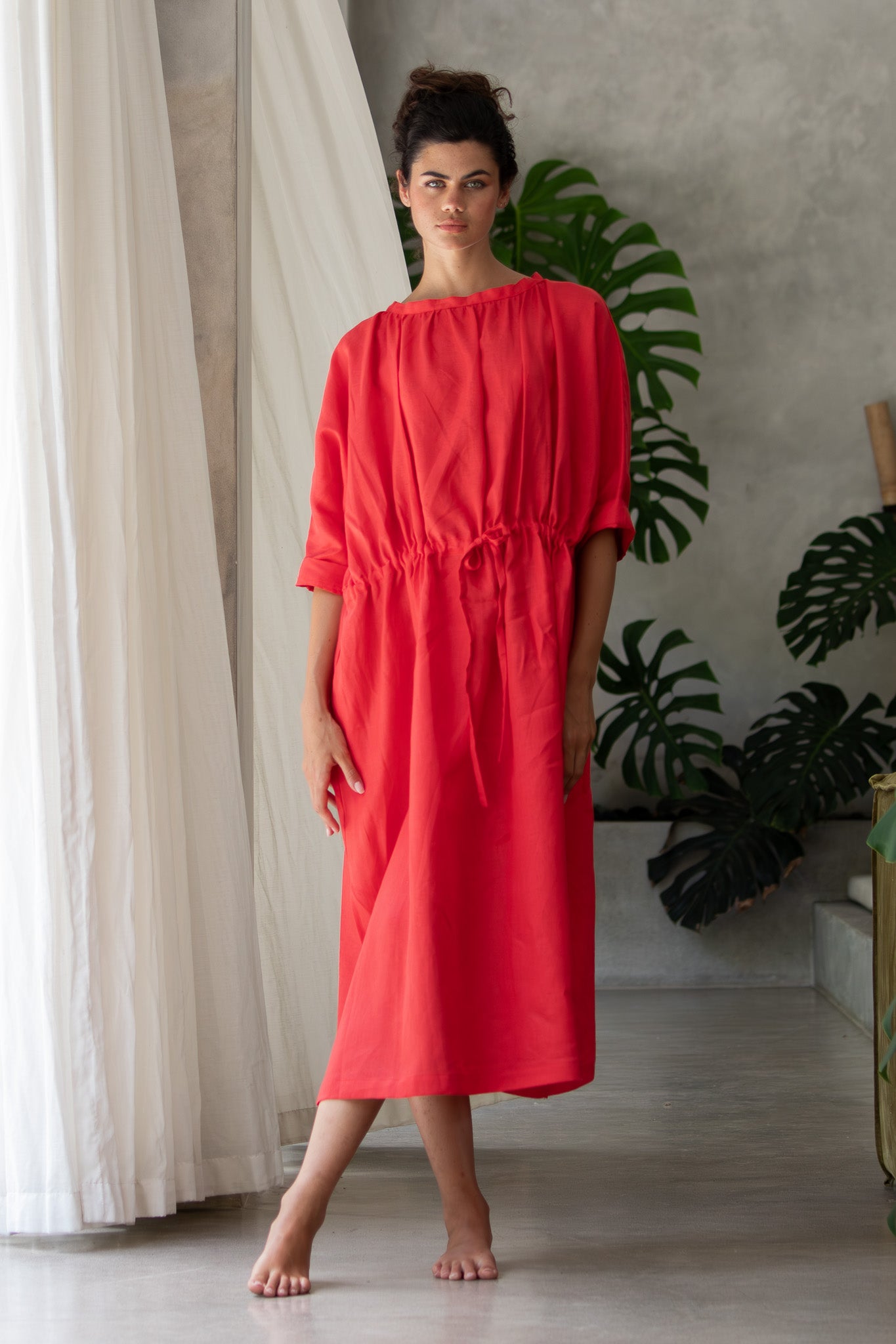 Luxury linen dress on stunning model standing looking at the camera 