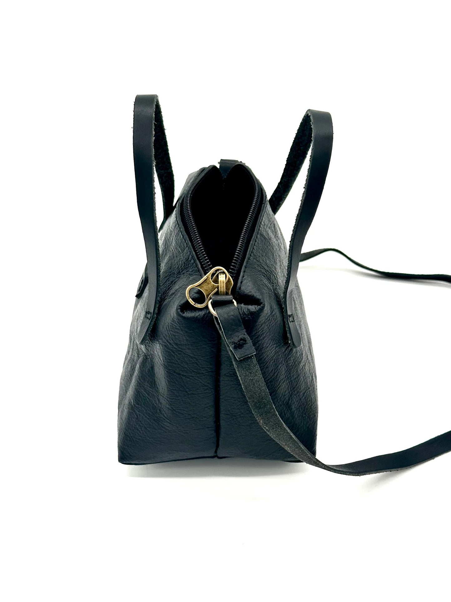 Side view of The Gemmina Bag in black, featuring premium leather straps, a secure zipper closure, and a sleek, compact design, perfect for daily use.