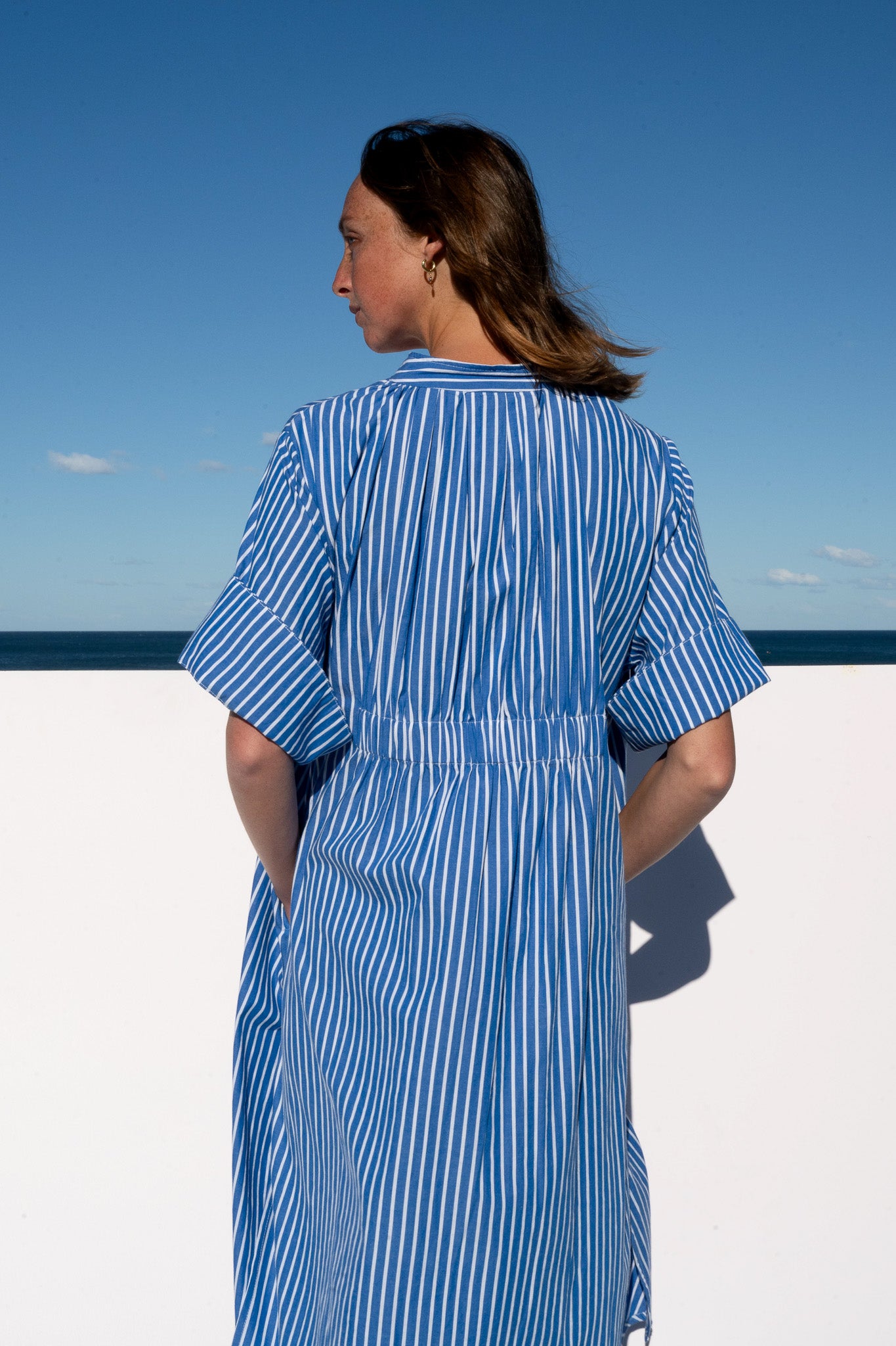 Close-up of the back pleats and elasticated waist of the Cabana Dress in blue stripe cotton.