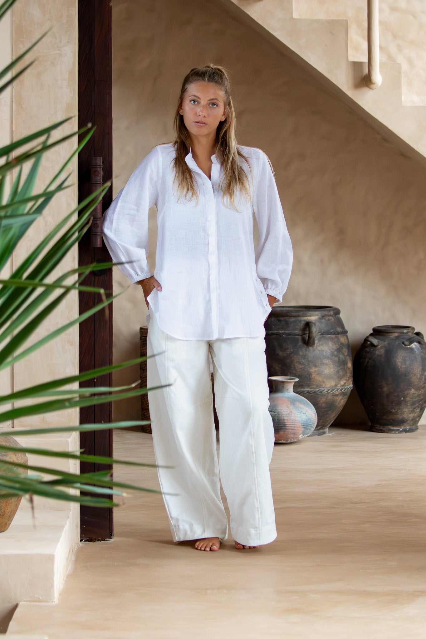 Model wearing Coconut Blouse in white from the front, showcasing its simple, timeless silhouette.