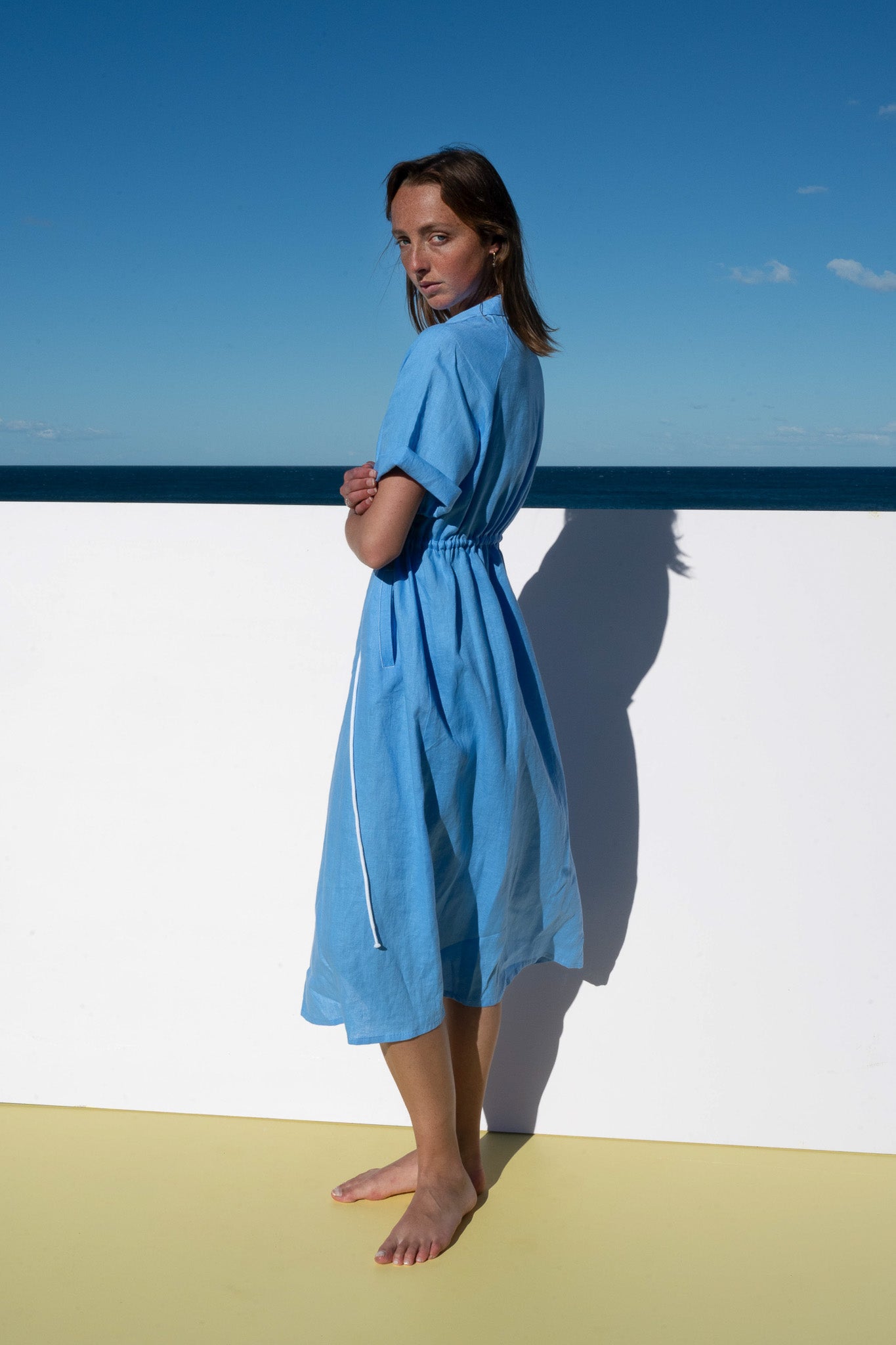 Side profile of The Boy and I Iconica Dress in blue with white zip and relaxed silhouette.