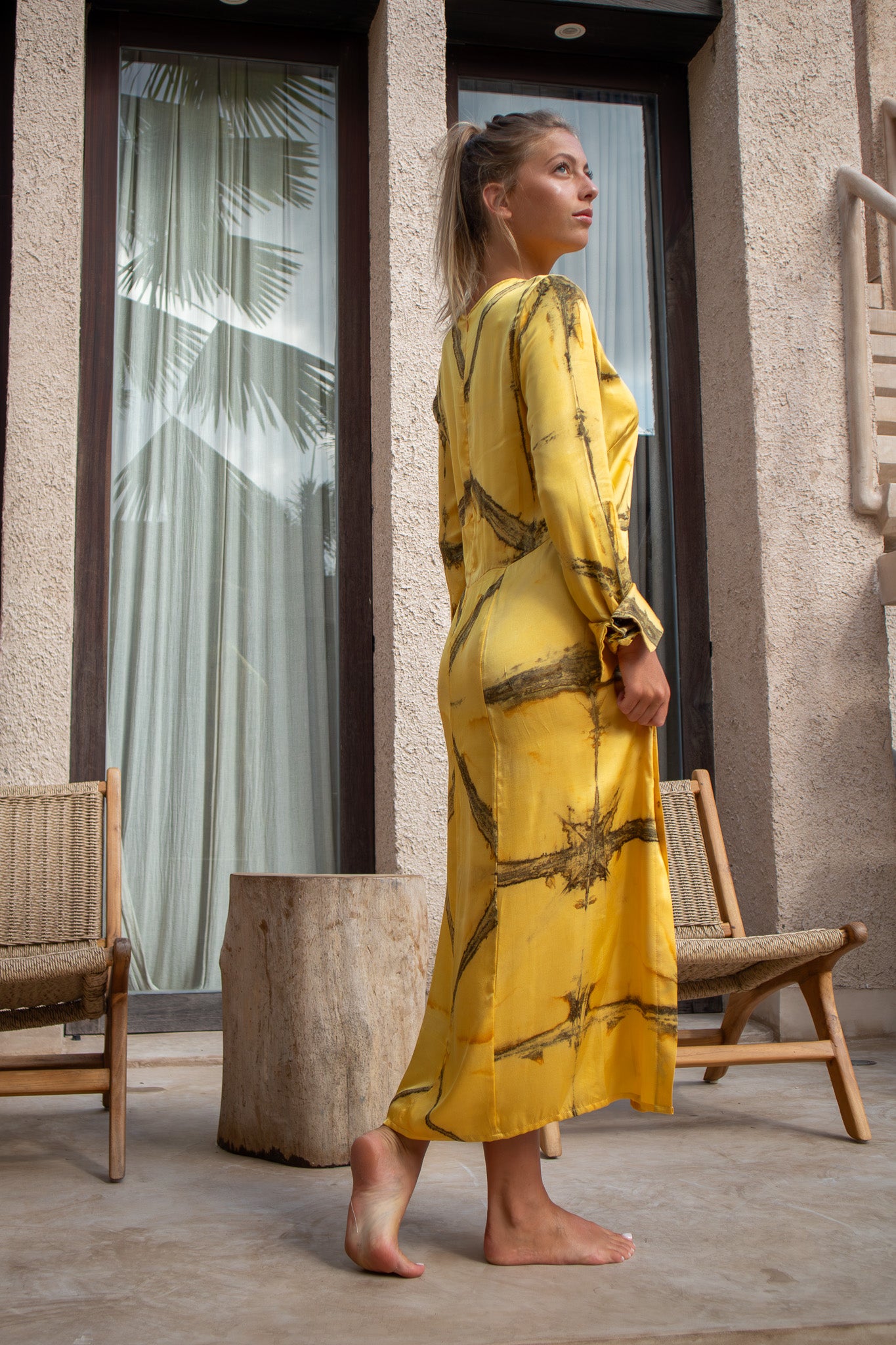 Side-back angle of the Maggie Dress in mango Shibori showcasing the natural drape and hand-dyed pattern.