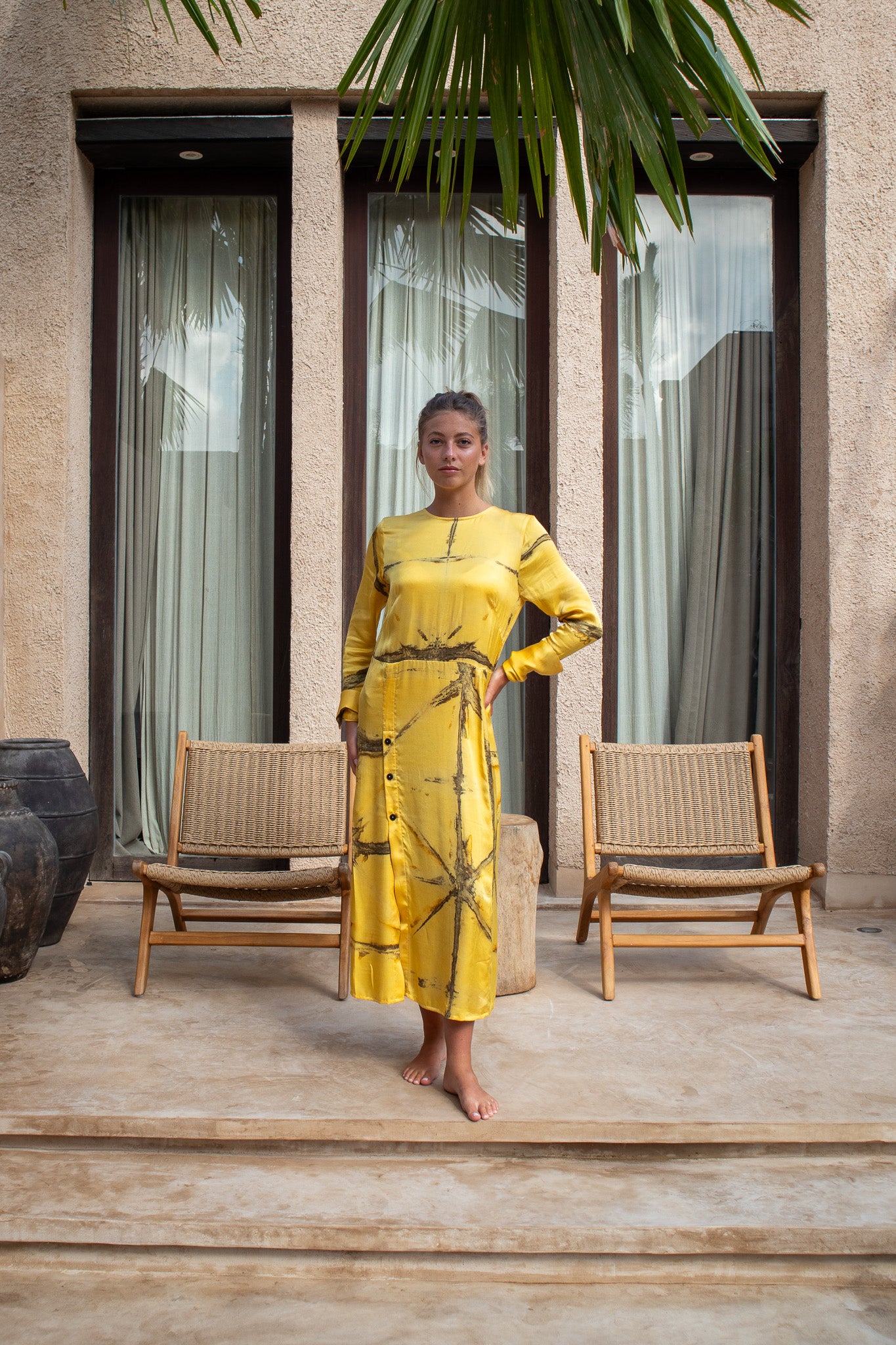Model wearing the Maggie Dress in mango Shibori, full-length front view with relaxed fit and button detailing.