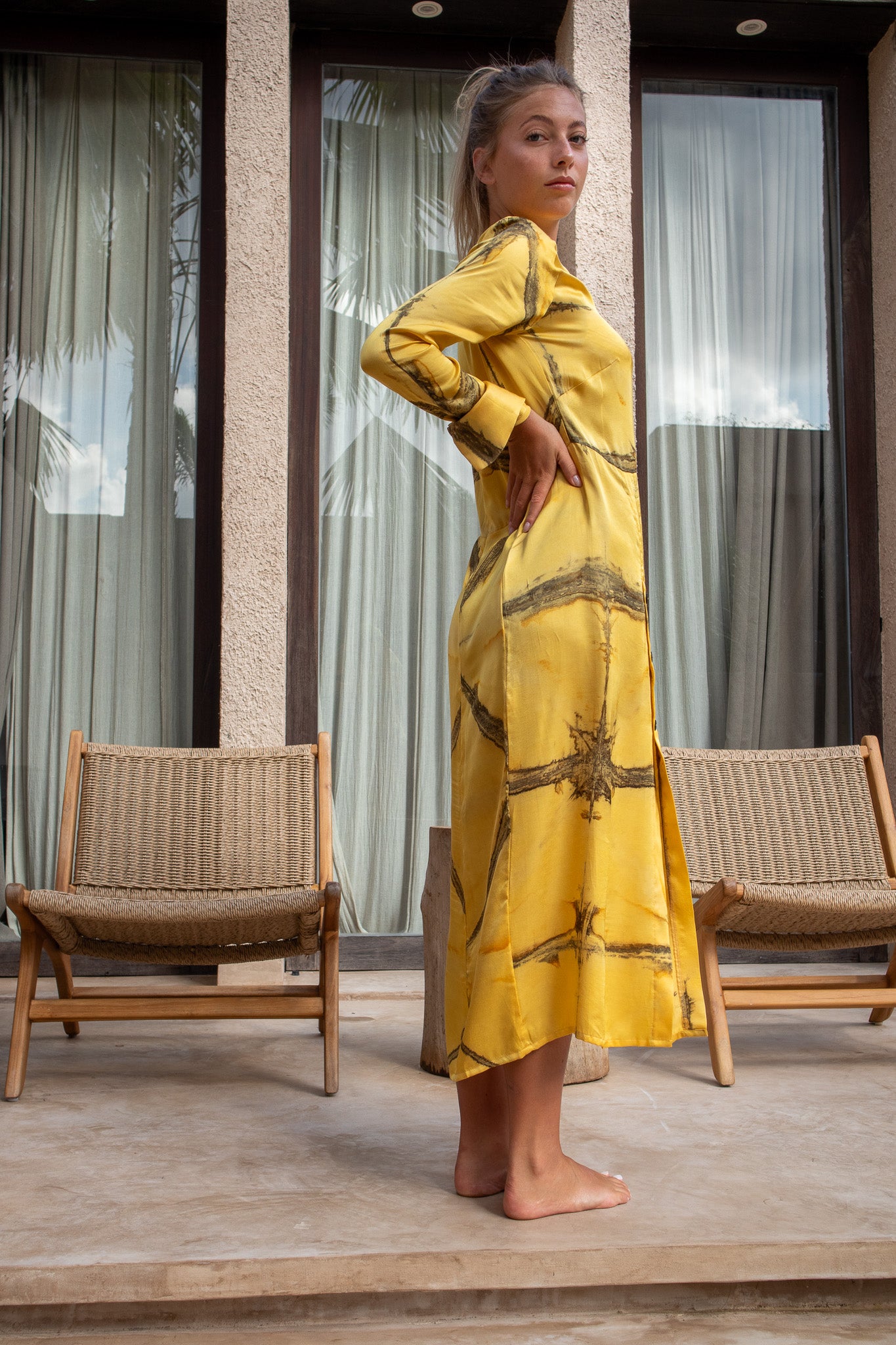 Side profile of the Maggie Dress in mango Shibori highlighting the flowing silhouette and artisan dye work.