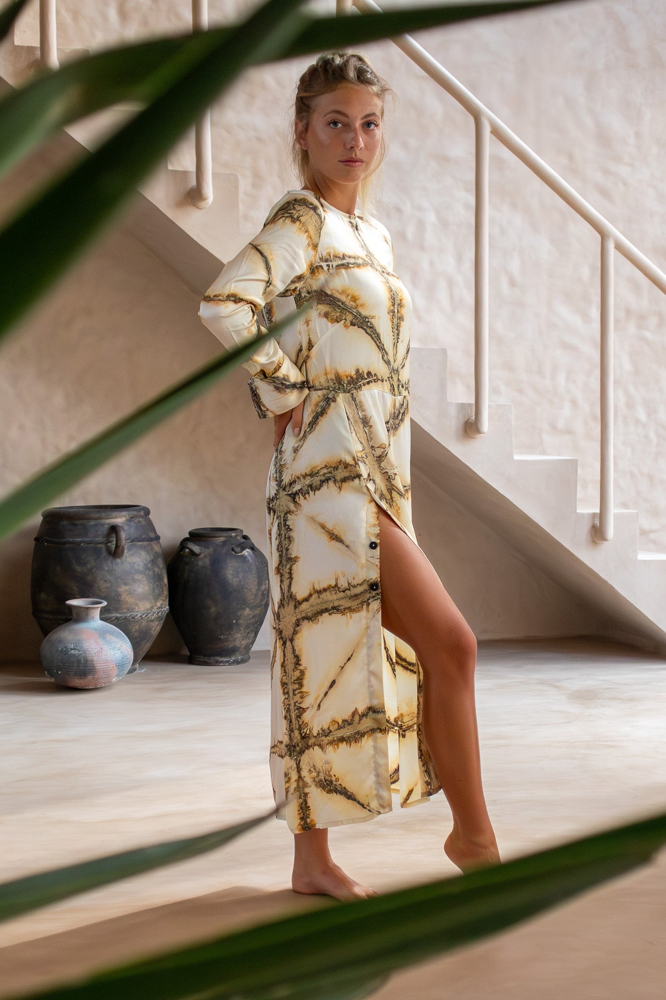 Side view of Maggie Dress in Earth Shibori with buttons and side slit, shot in natural light