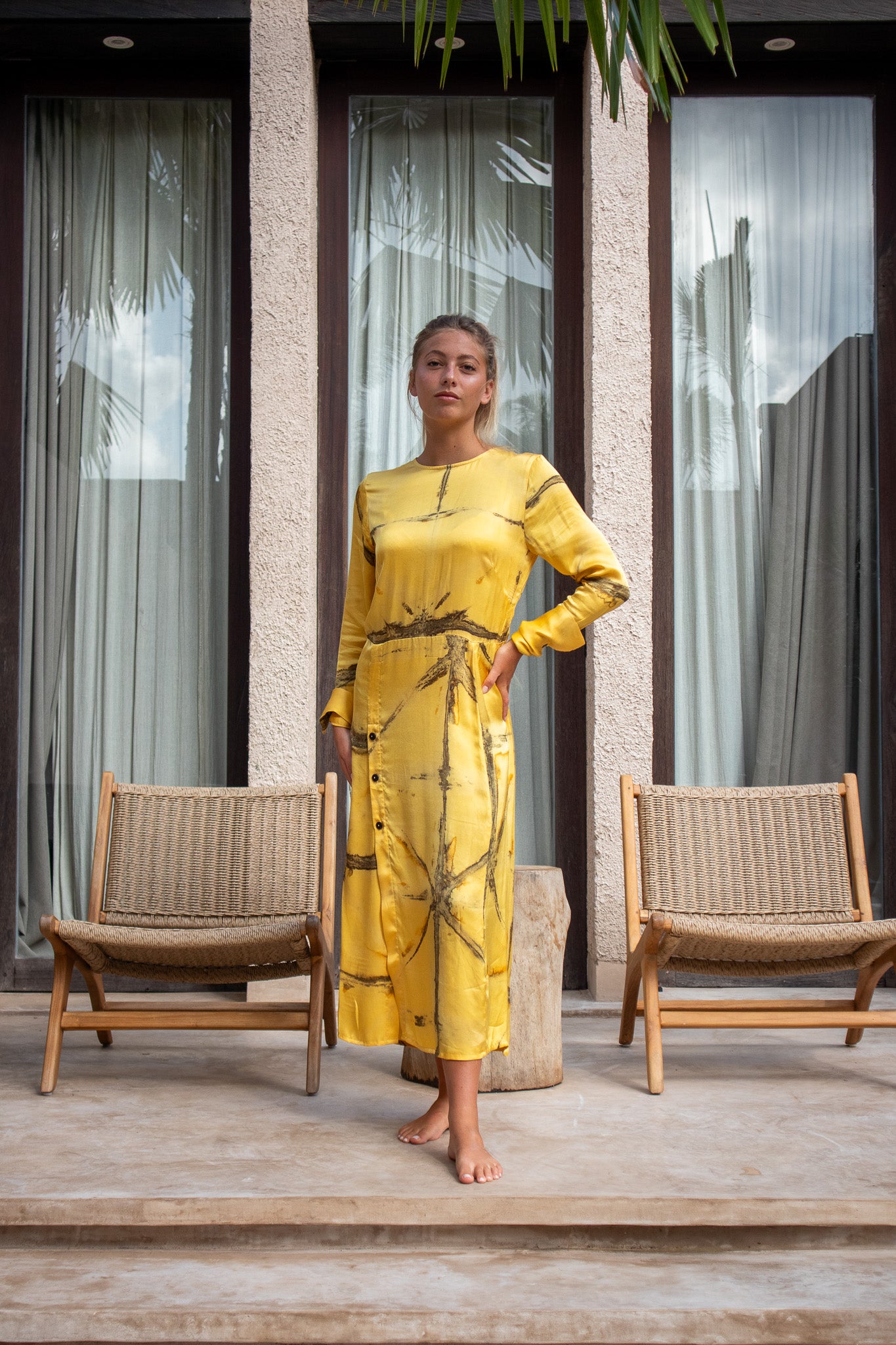 Front view of Maggie Dress in Mango Shibori with hands on hips and button detailing