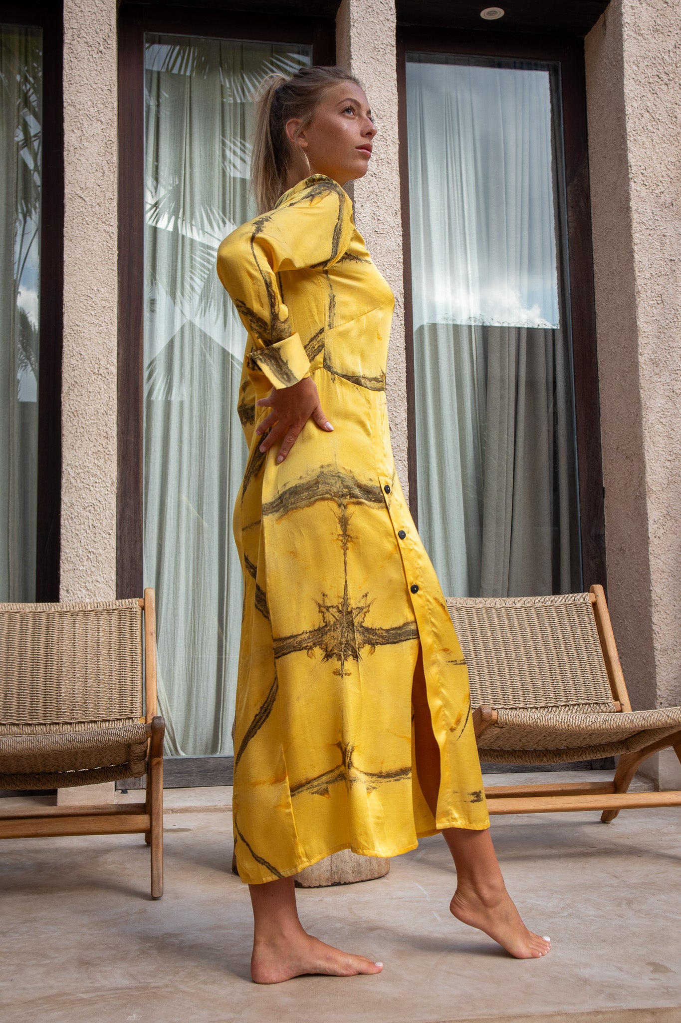 Side profile of the Maggie Dress in Mango Shibori with buttons and high slit