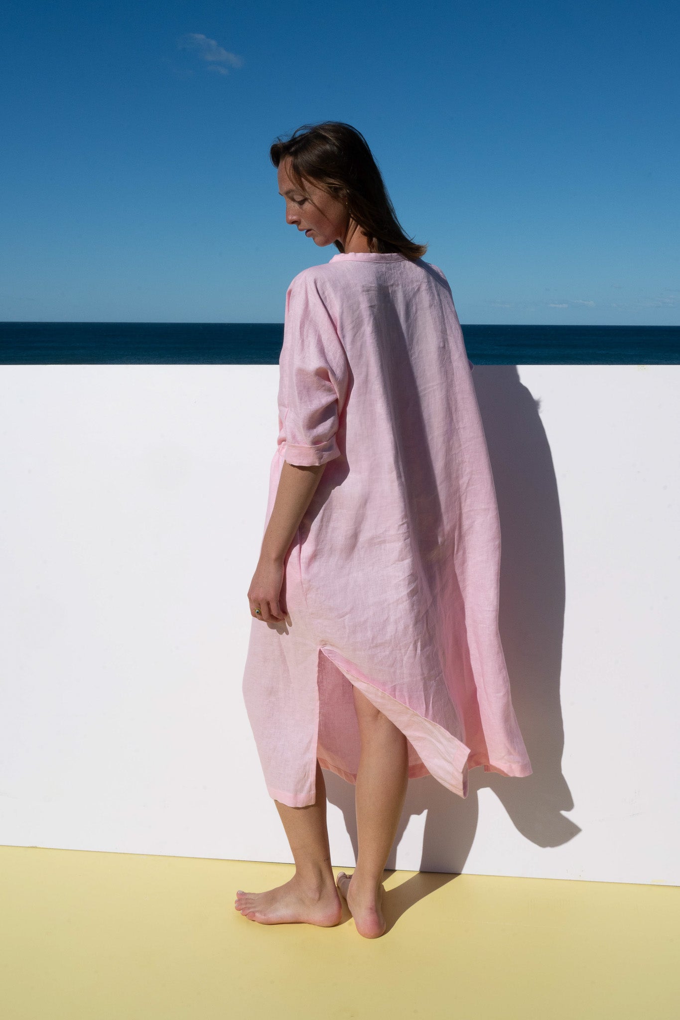 Back and side view of The Moments Dress in Bonbon Pink, showing relaxed fit and slit hem detail.