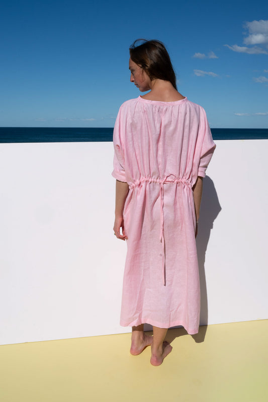 Back view of The Moments Dress in Bonbon Pink, showing relaxed fit with drawstring waist tie.
