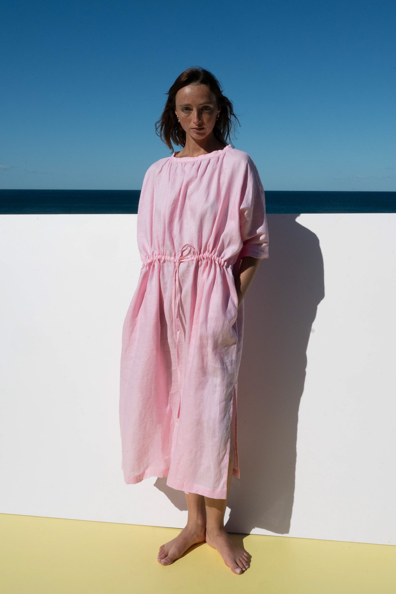 Model wearing The Moments Dress in Bonbon Pink, front view with drawstring waist.