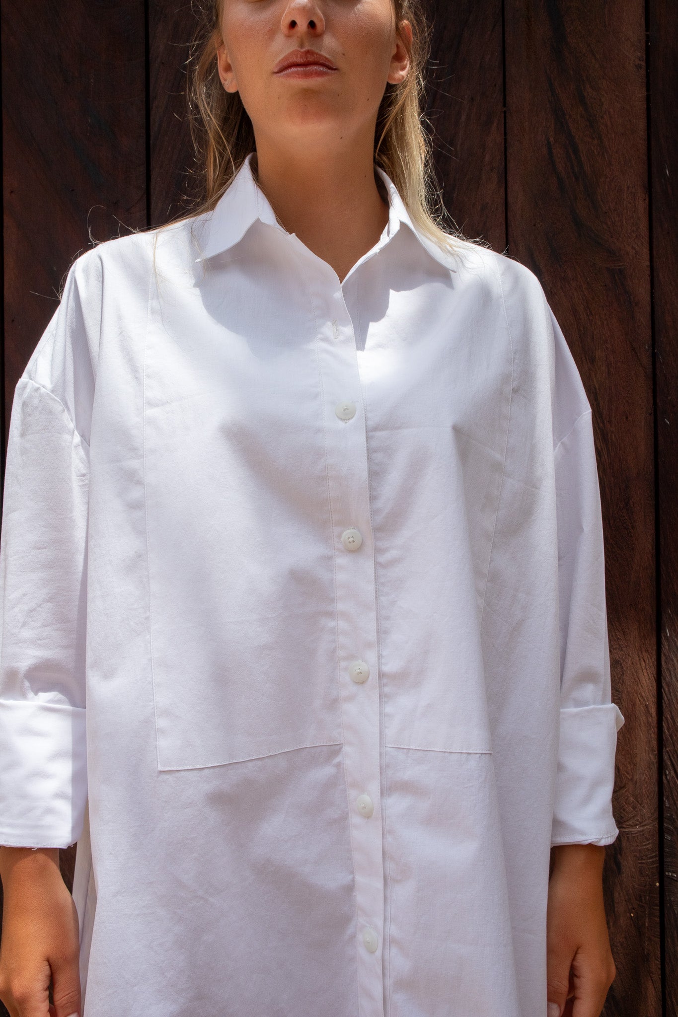 Close-up of The Boyfriend Tux Shirt showing the button placket, collar, and large chest pockets in crisp white cotton.