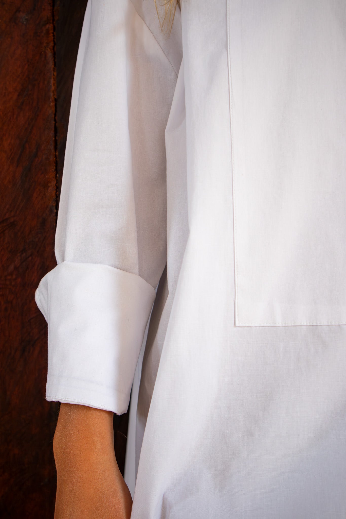 Close-up of The Boyfriend Tux Shirt sleeve and pocket stitching detail in crisp white cotton fabric.