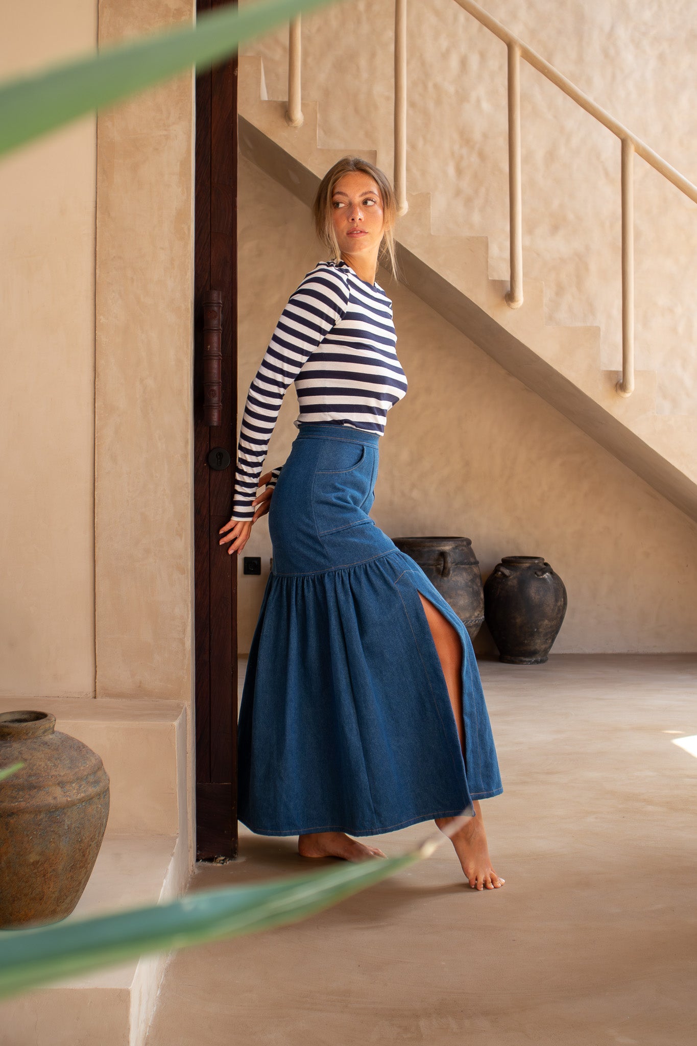 Side view of The Boy and I Cancan Skirt in denim, featuring the side slit and gathered hem, styled with a striped top.