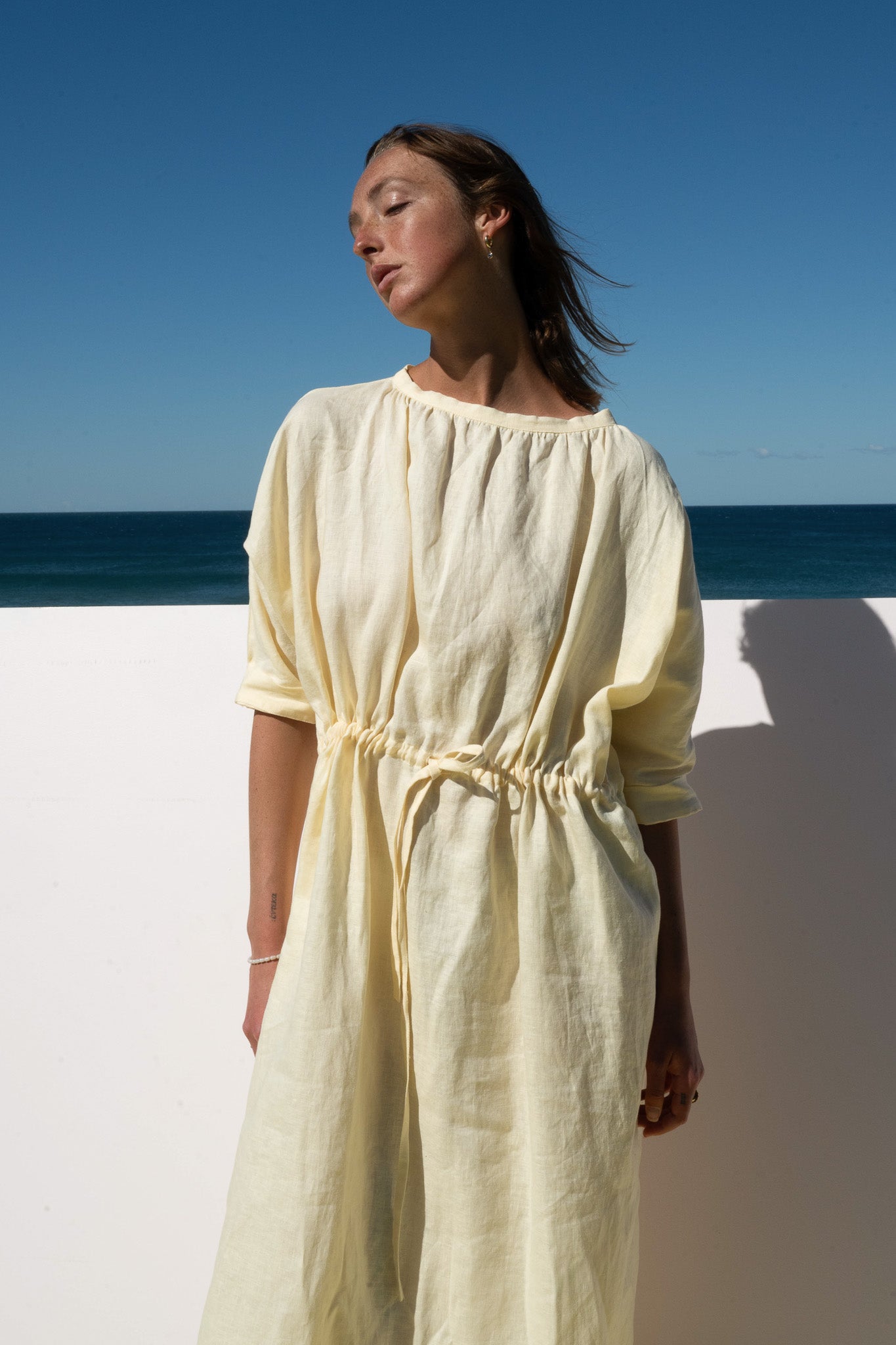 The Moments Dress in yellow linen – close up of neckline, relaxed sleeves and gathered waist
