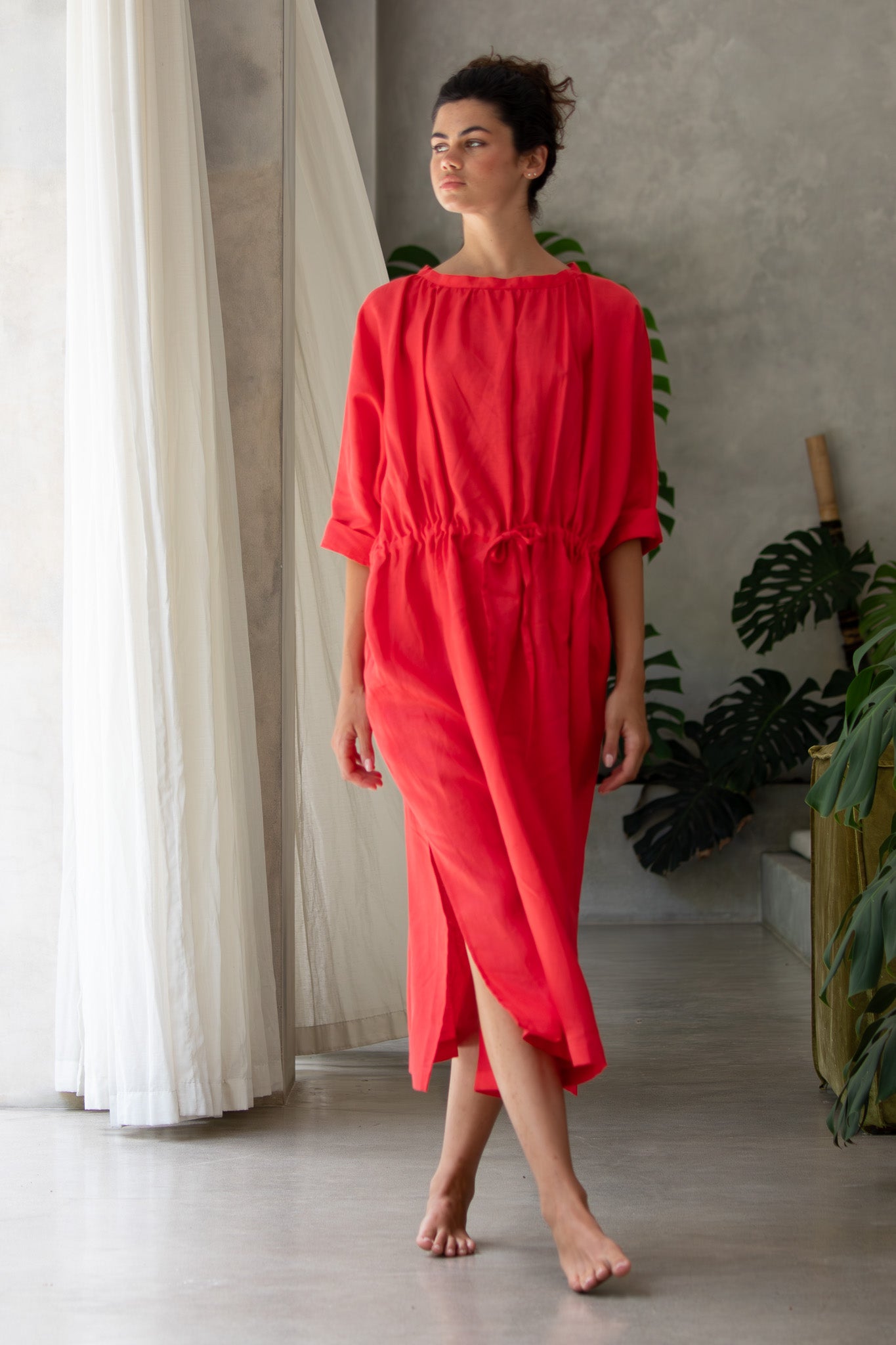 Model walking towards the camera wearing a luxury red linen dress from designer label The Boy&I