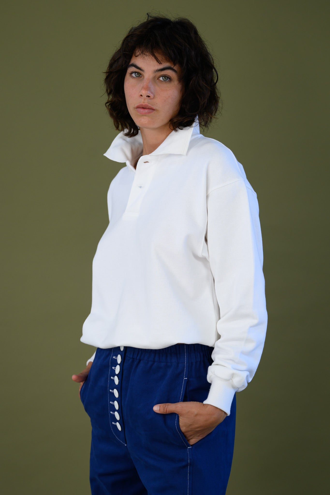 Front detail of white cotton jumper showing neckline and fabric texture