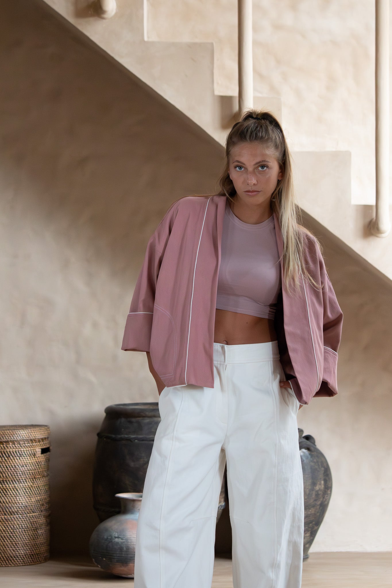 Close-up front view of the Yoko Kimono Shortie in Dusty Pink, styled with a crop top and white pants, showing subtle white contrast topstitching.