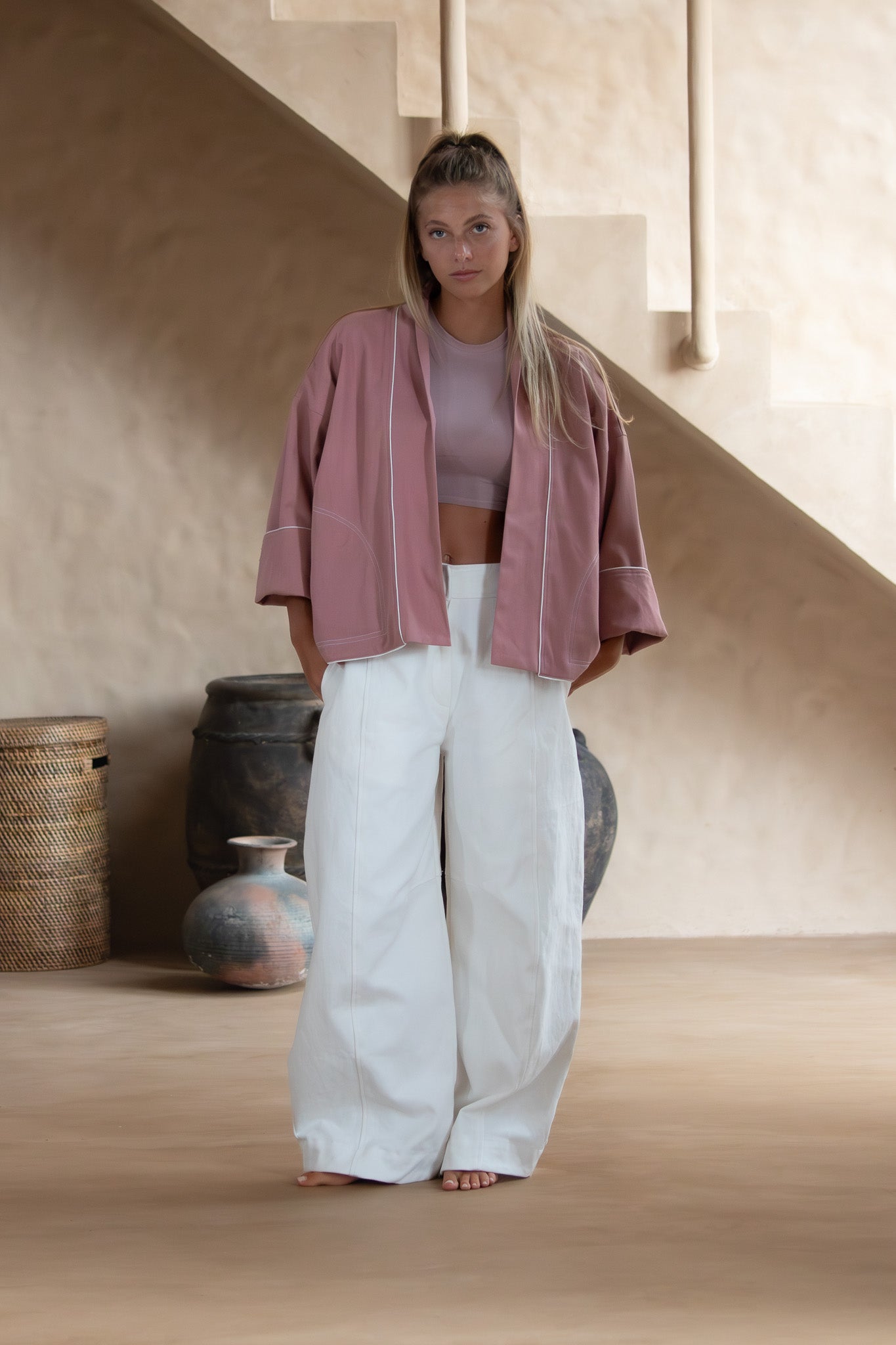 Full-body shot of the Yoko Kimono Shortie in Dusty Pink styled with wide white pants, set against a serene Japandi-inspired indoor backdrop.