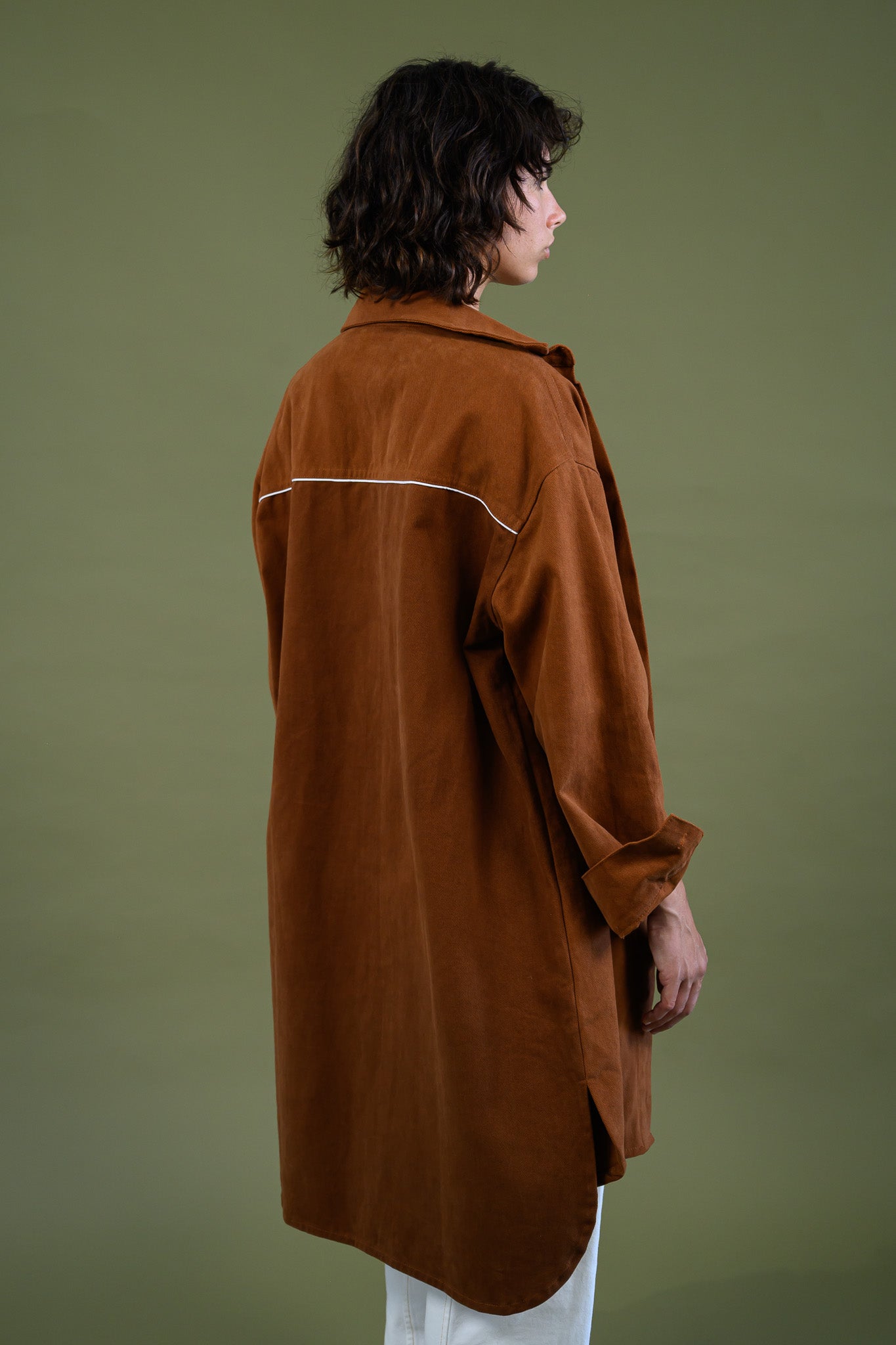 Angled back view of Caramel cotton canvas denim shirt coat showing contrast binding detail