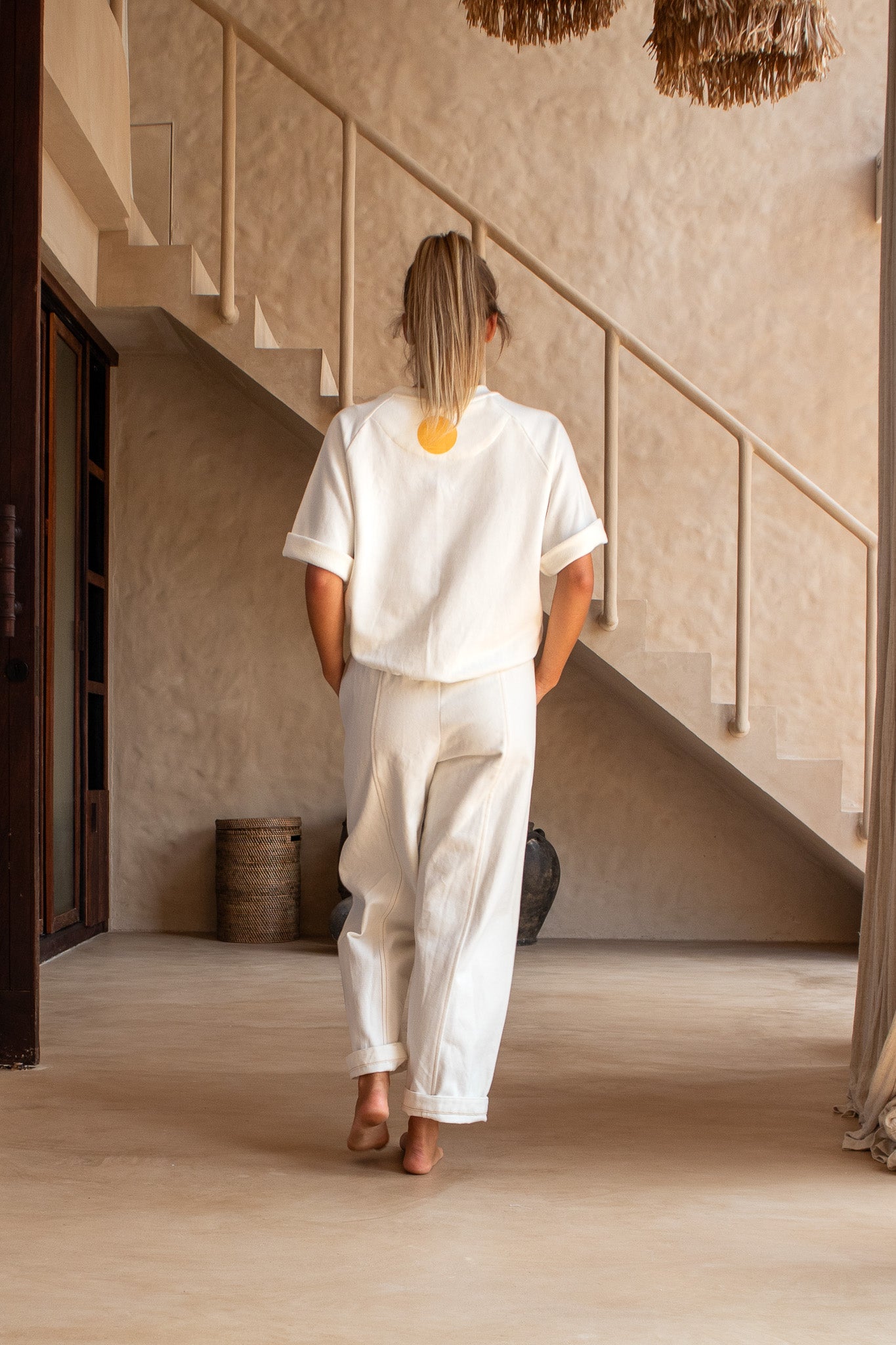  Back view of model wearing Blaze Jogger pants and organic cotton sweatshirt with yellow dot detail.