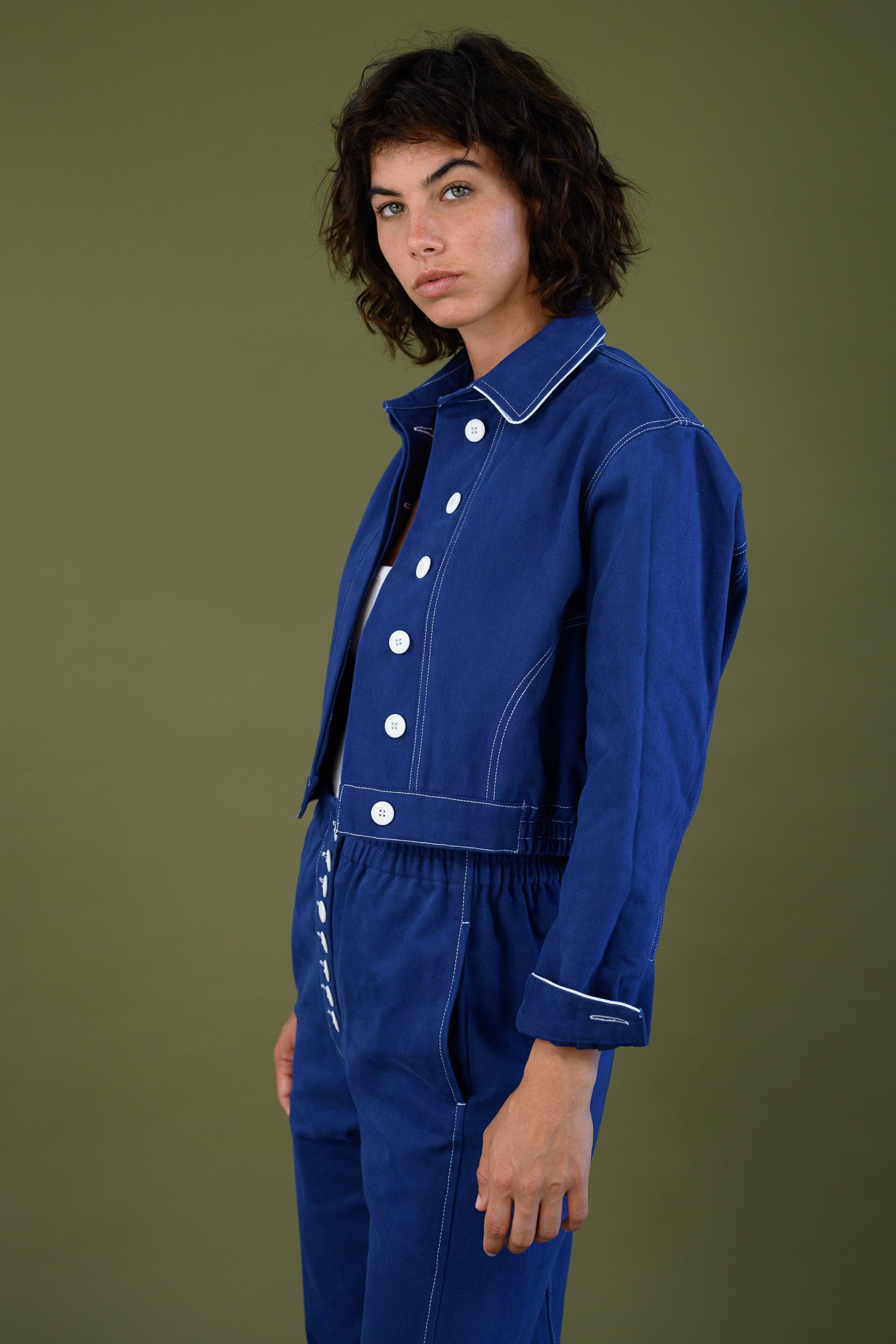 Front view of blue cotton twill jacket highlighting oversized white buttons