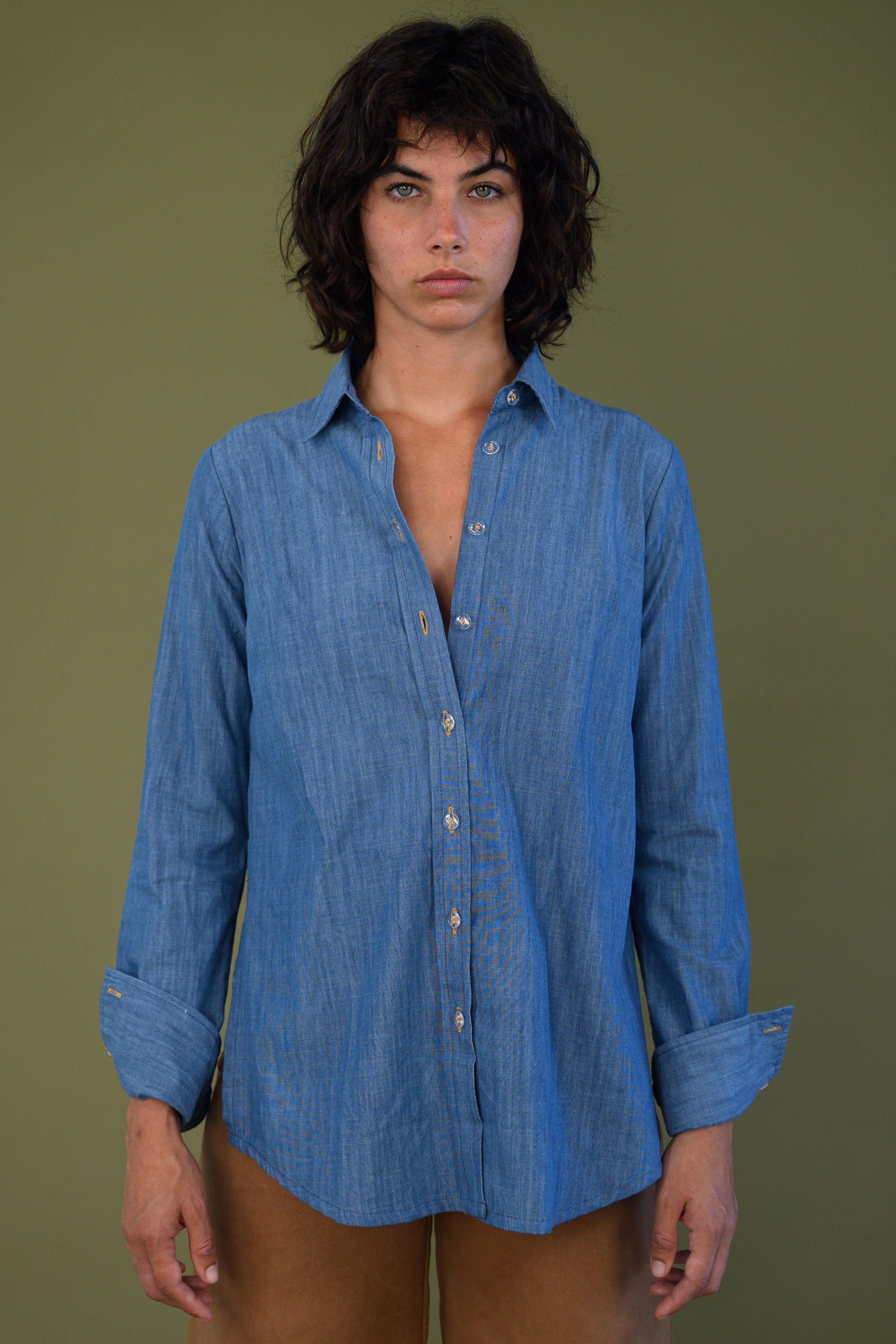 Front view of blue denim shirt styled with brown pants
