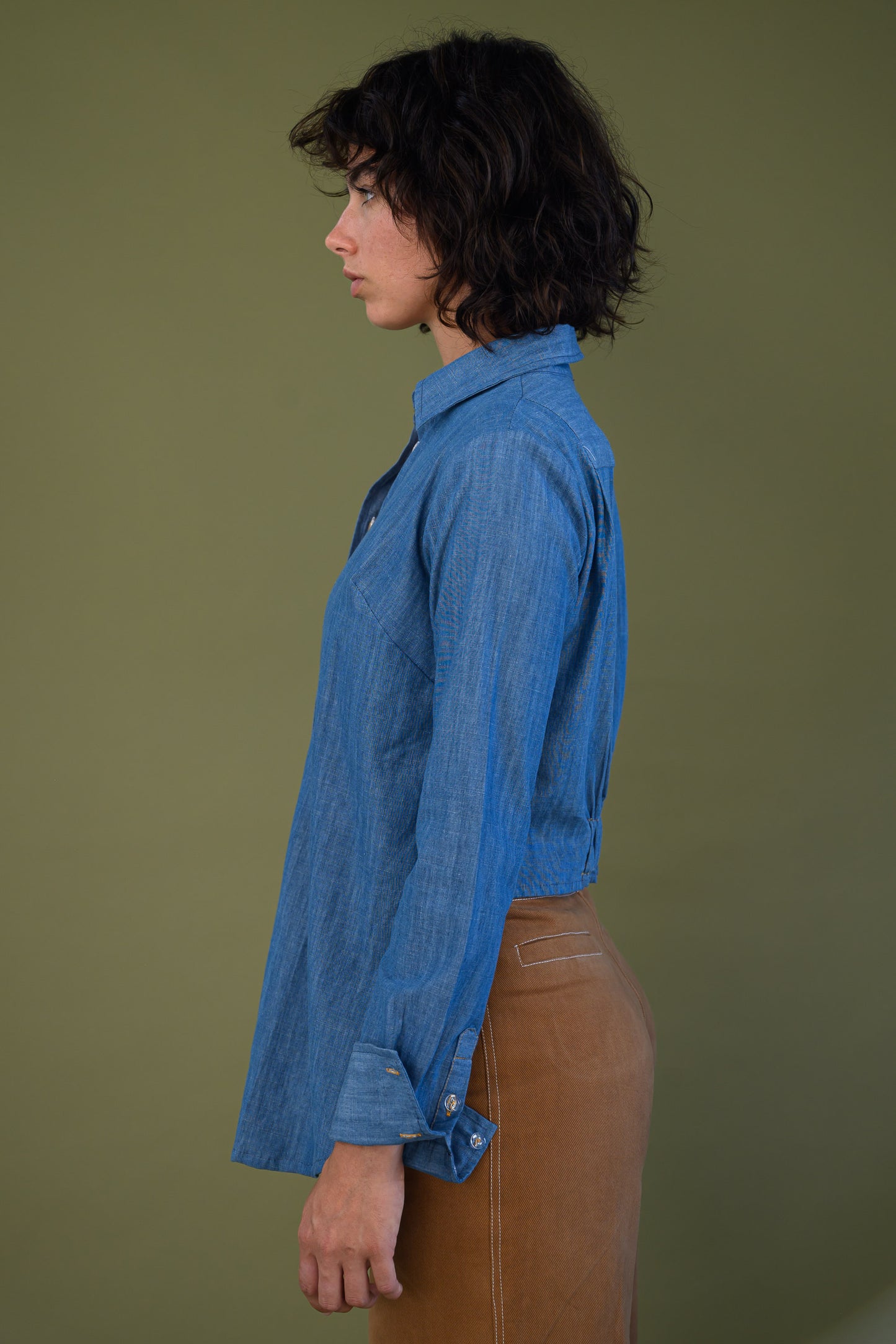 Side profile of blue denim shirt showing relaxed silhouette and fit