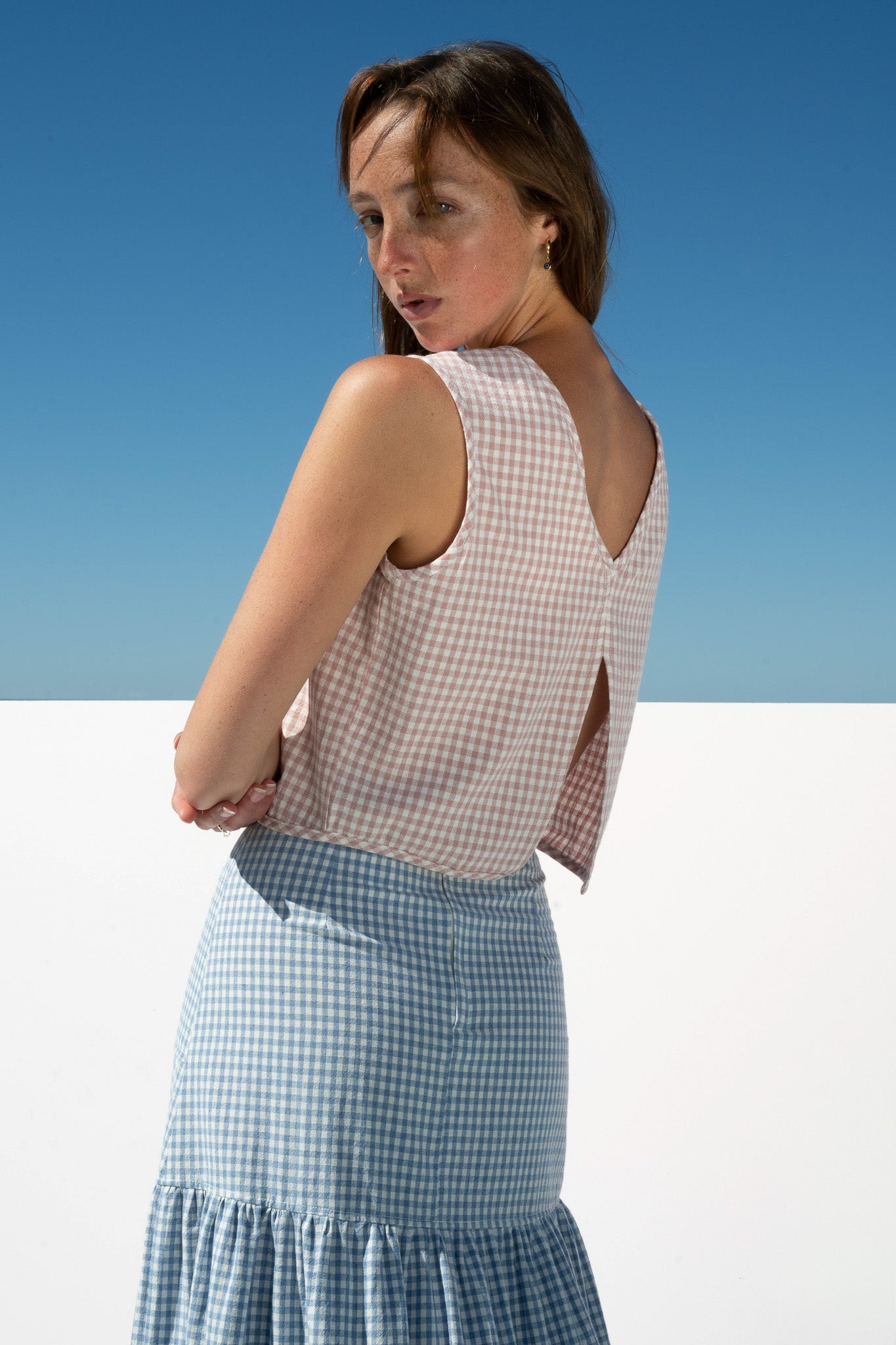 Back view of The Boy & I Box Crop Top in blush gingham featuring V-back split detail