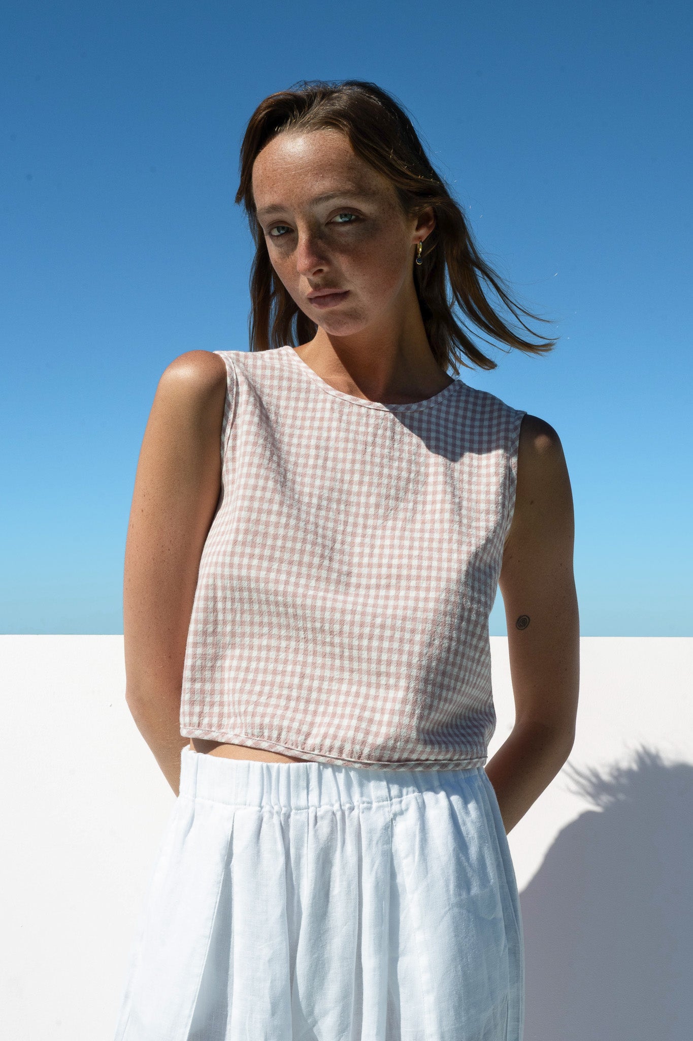 Close-up detail of The Boy & I Box Crop Top in blush gingham cotton with cropped hemline