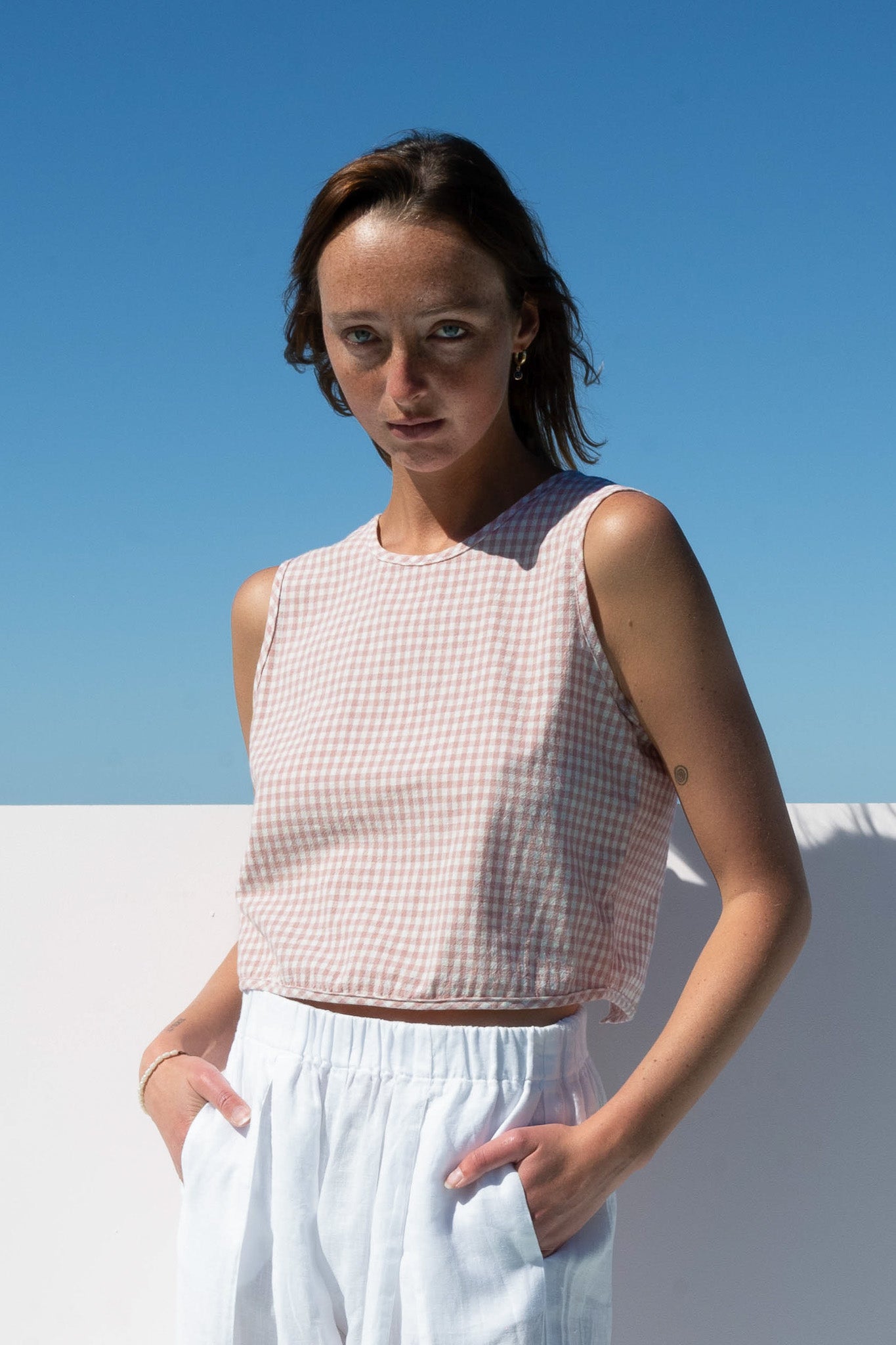 Angled side view of The Boy & I Box Crop Top in blush gingham cotton linen blend