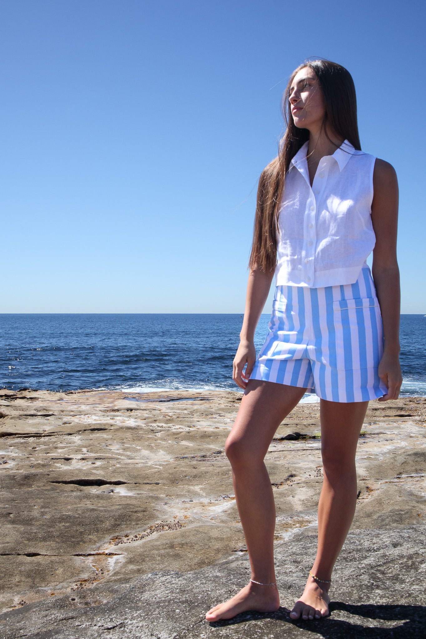 Full length view of Calippo Short in sky blue stripe on model standing on rocks