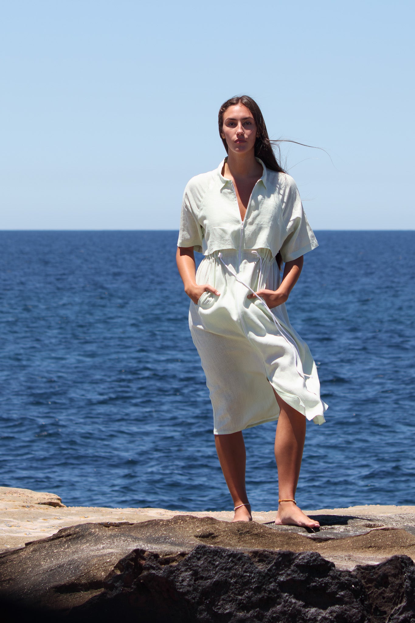 Full-length front view of the Iconica Dress in French linen, featuring a wide white zip, relaxed silhouette and adjustable drawcord waist.