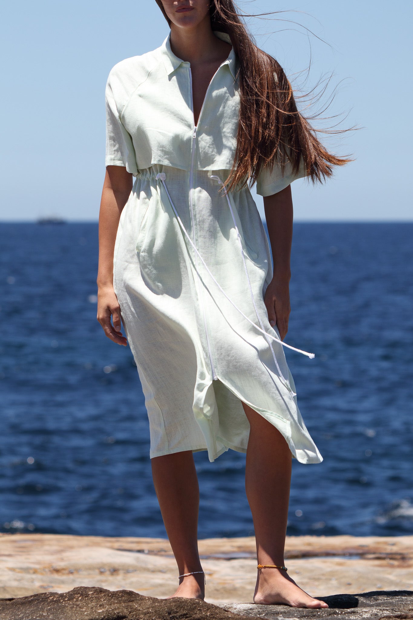 Mid-length view of the Iconica Dress showing the white topstitching, wide front zip and organic cotton drawcord at the waist.