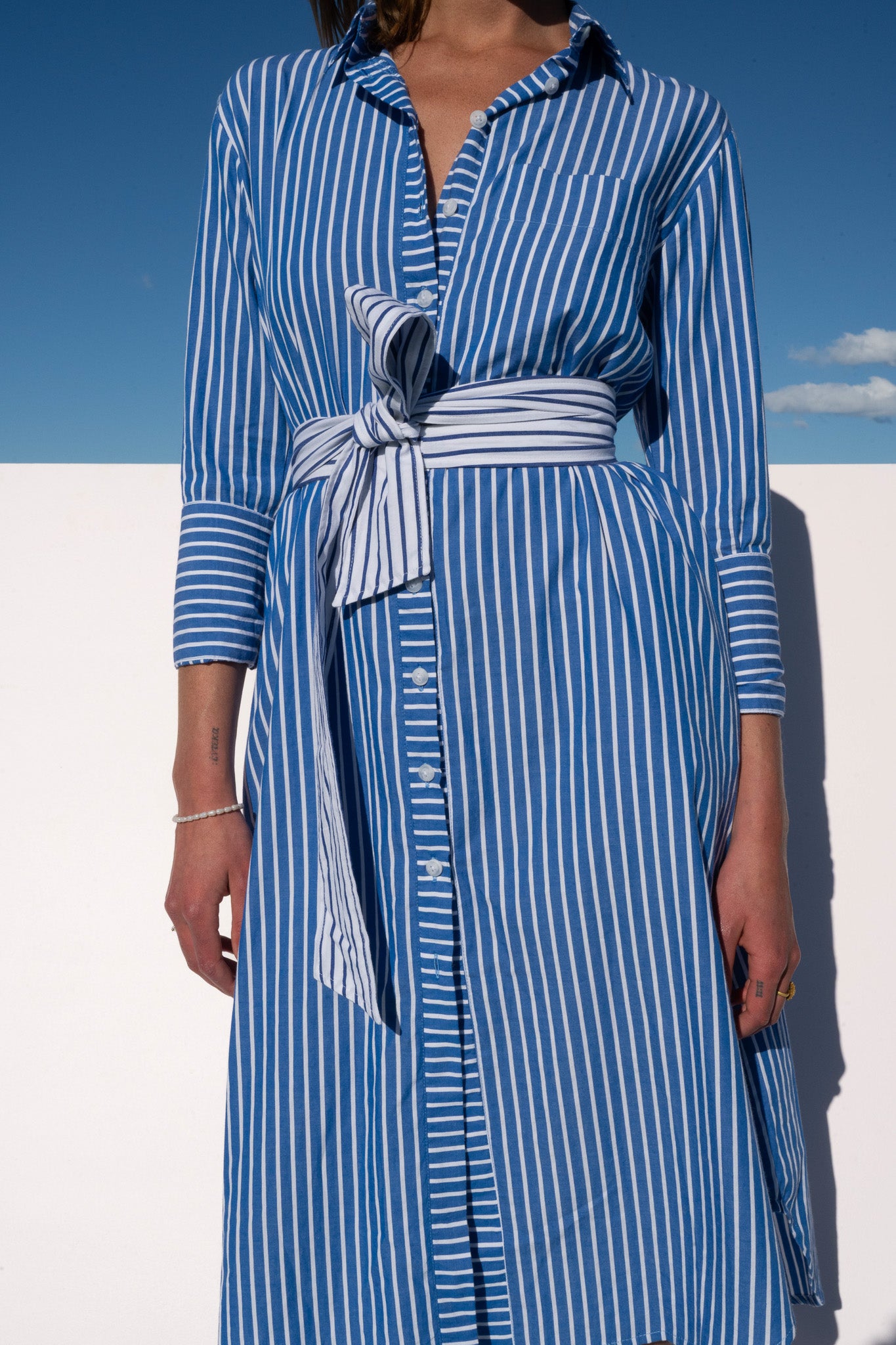 Close-up front view of The Boy & I Bronte Dress in blue and white pinstripe with waist tie