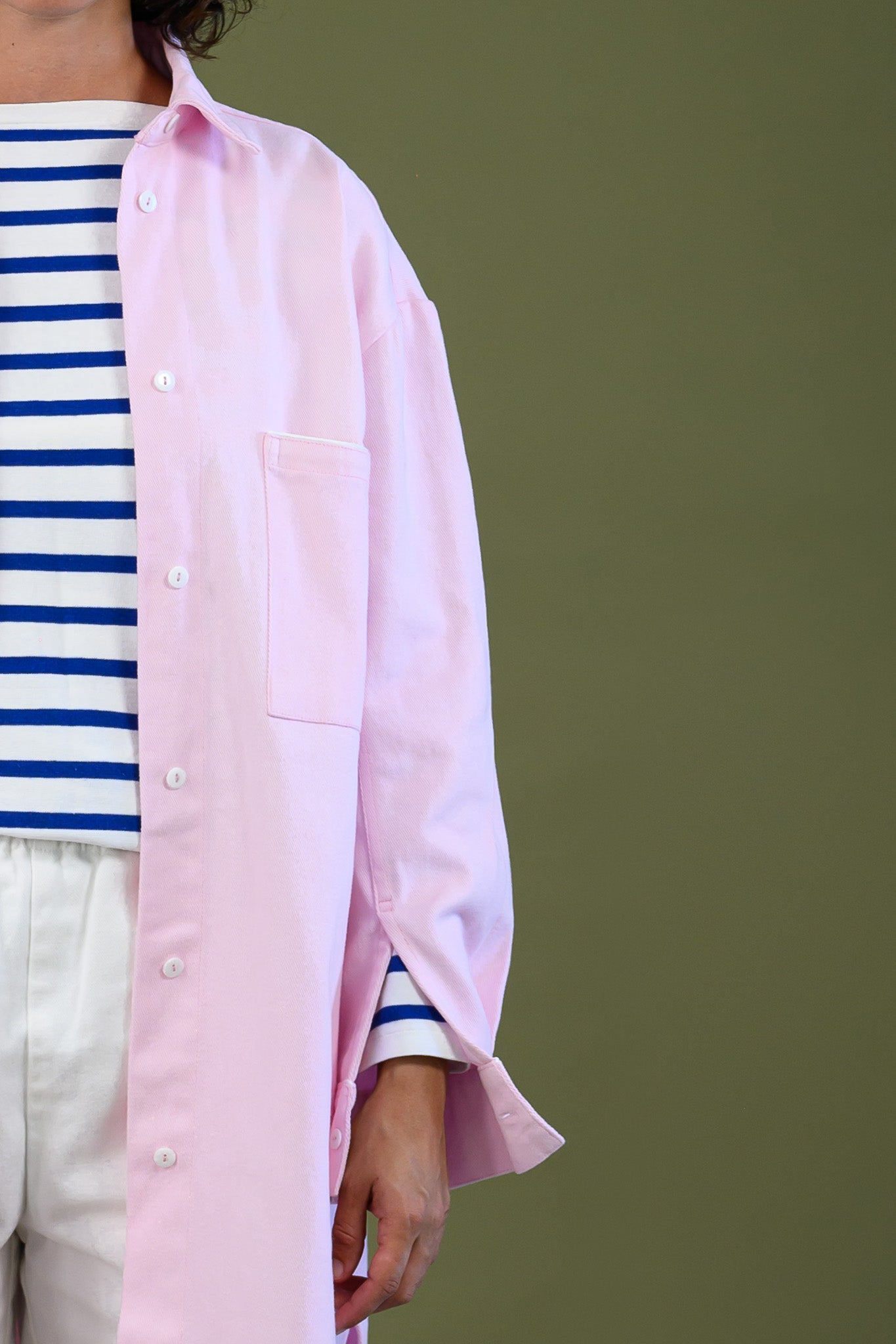 Pink canvas denim jacket detail showing front pocket buttons and relaxed cotton fabric