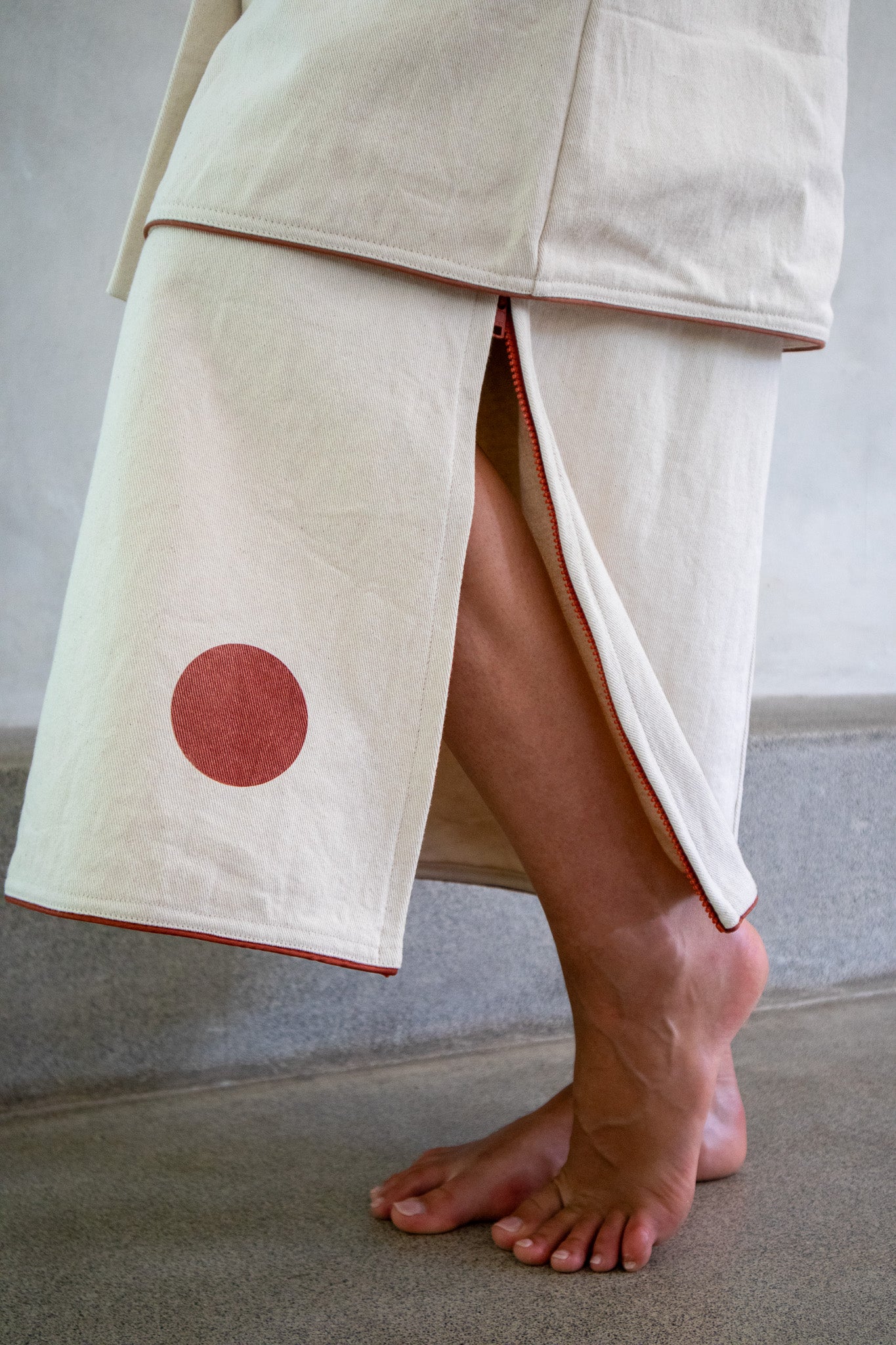 Close detailed shot of a denim skirt with red dot detail and side zipper