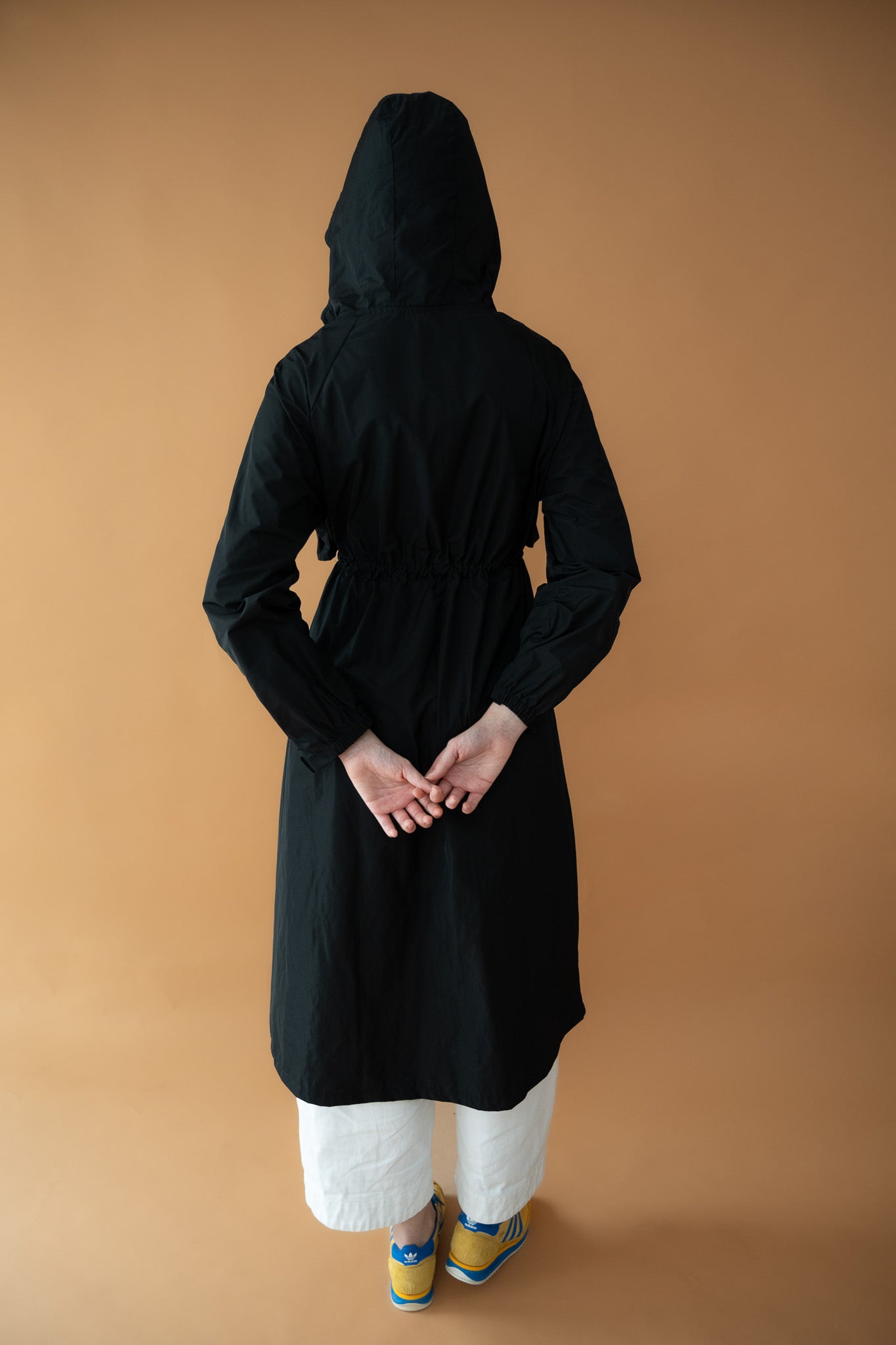 Back view of Cloud Breaker raincoat with hood on and gathered waist detail
