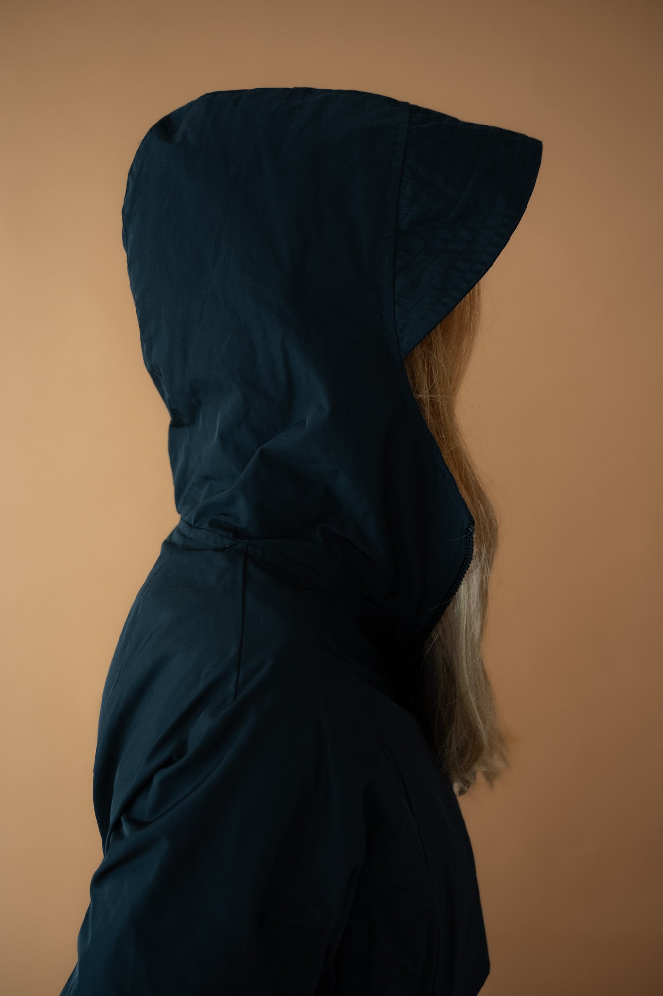 Side view of the Cloud Breaker raincoat showing structured hood and technical taffeta fabric