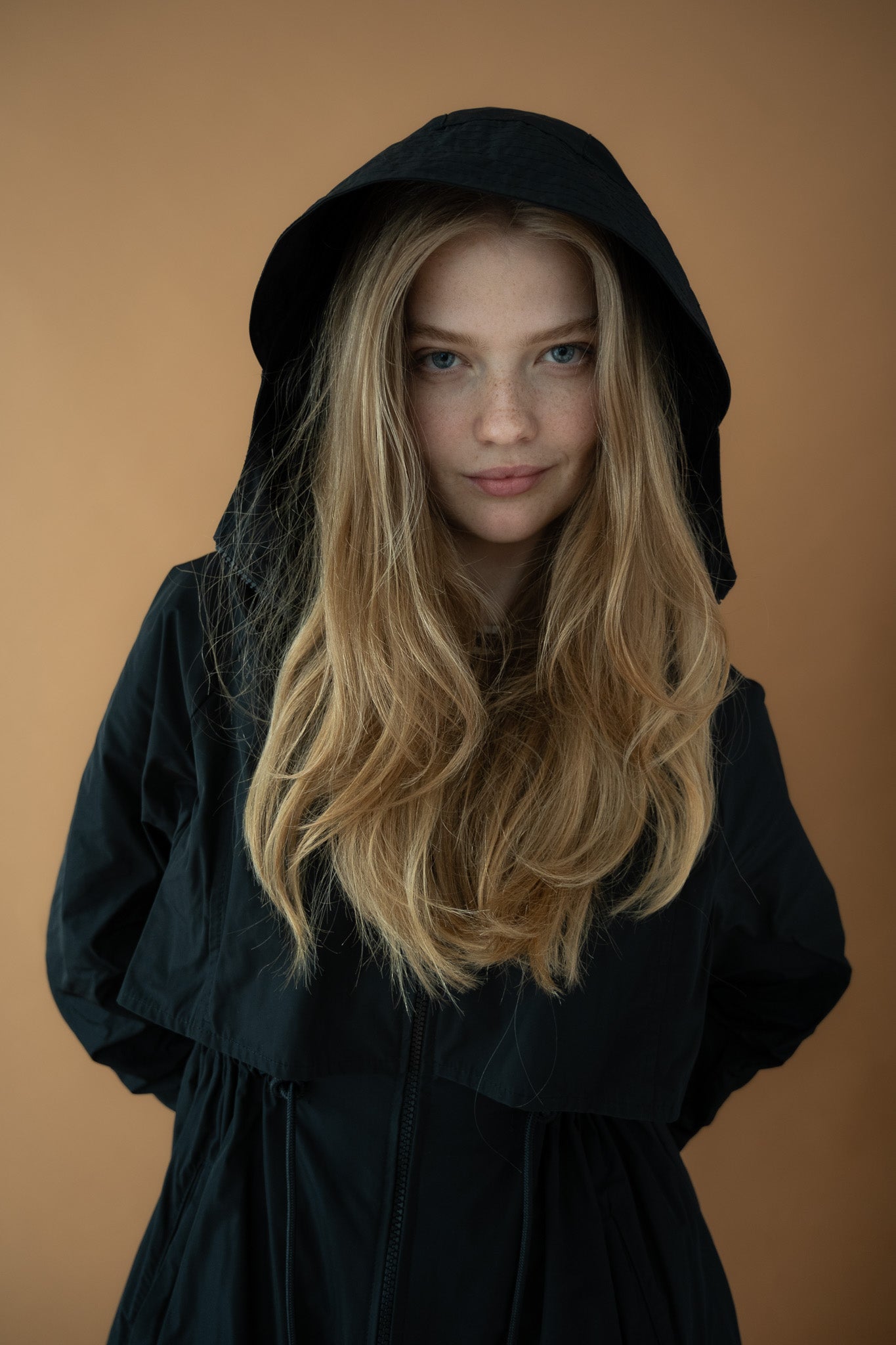 Front close-up of model wearing Cloud Breaker raincoat with hood up