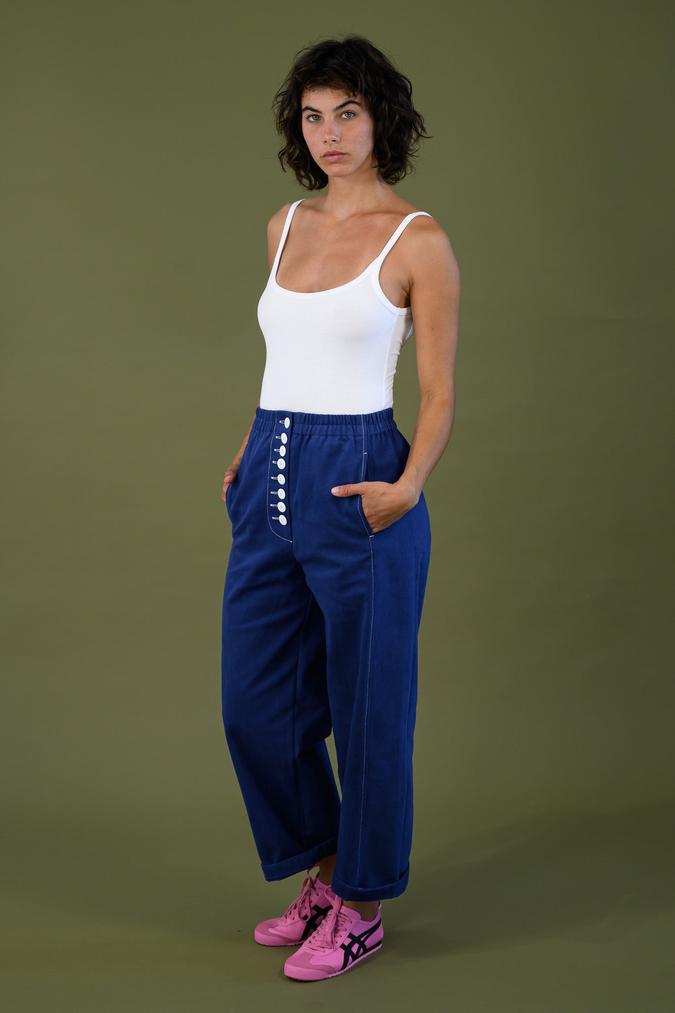Front view of French navy cotton twill button pants highlighting front button placket styled with white tank