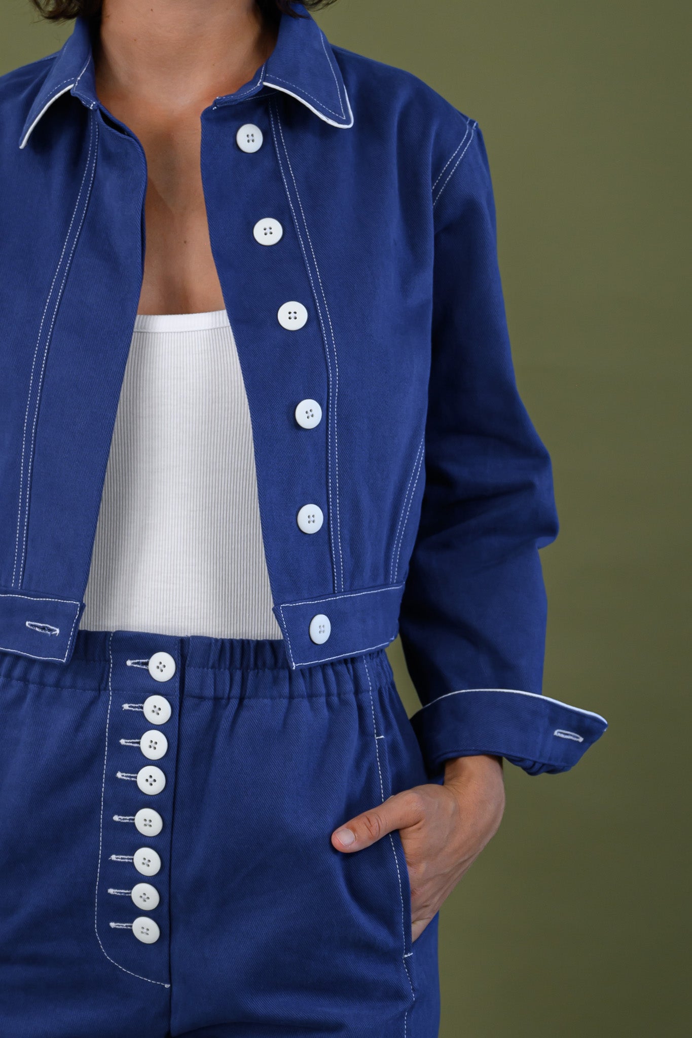 Front detail of French navy cotton twill button pants showing button placket and contrast stitching
