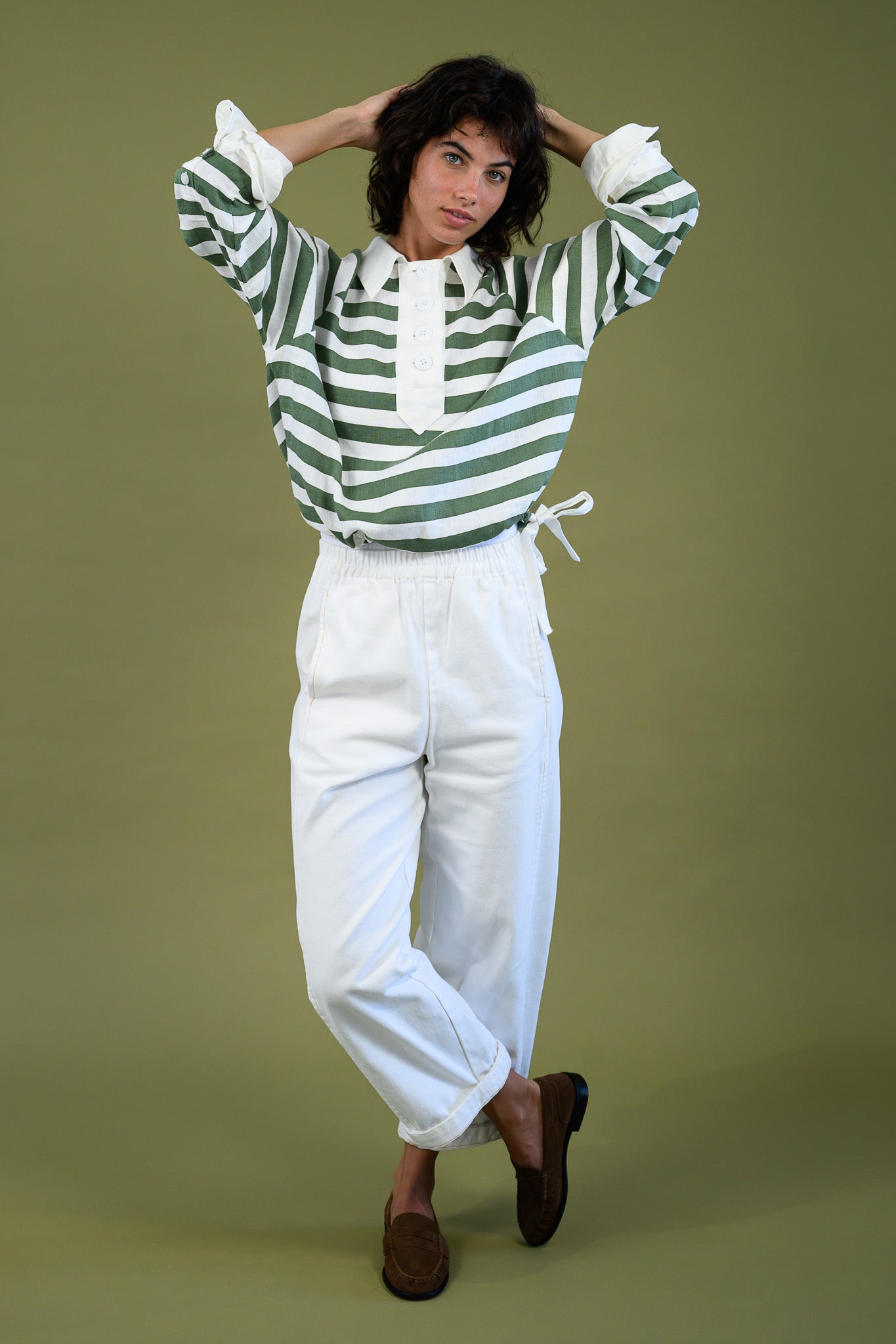 Harrington shirt meadow green stripe linen full body front view styled with white pants showing relaxed fit, contrast collar and drawcord hem