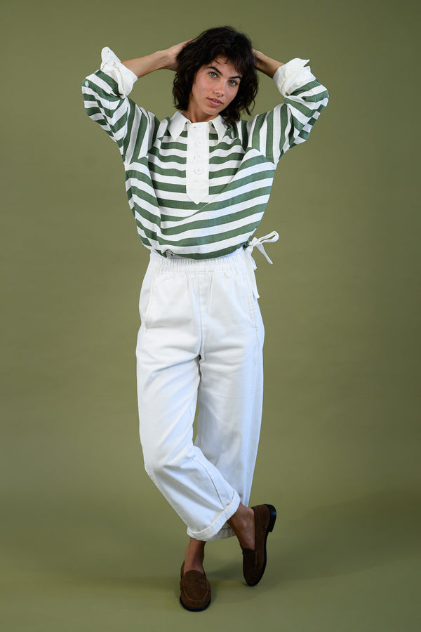 Model wearing harrington rugby shirt in linen with hands over her head show the fit.
