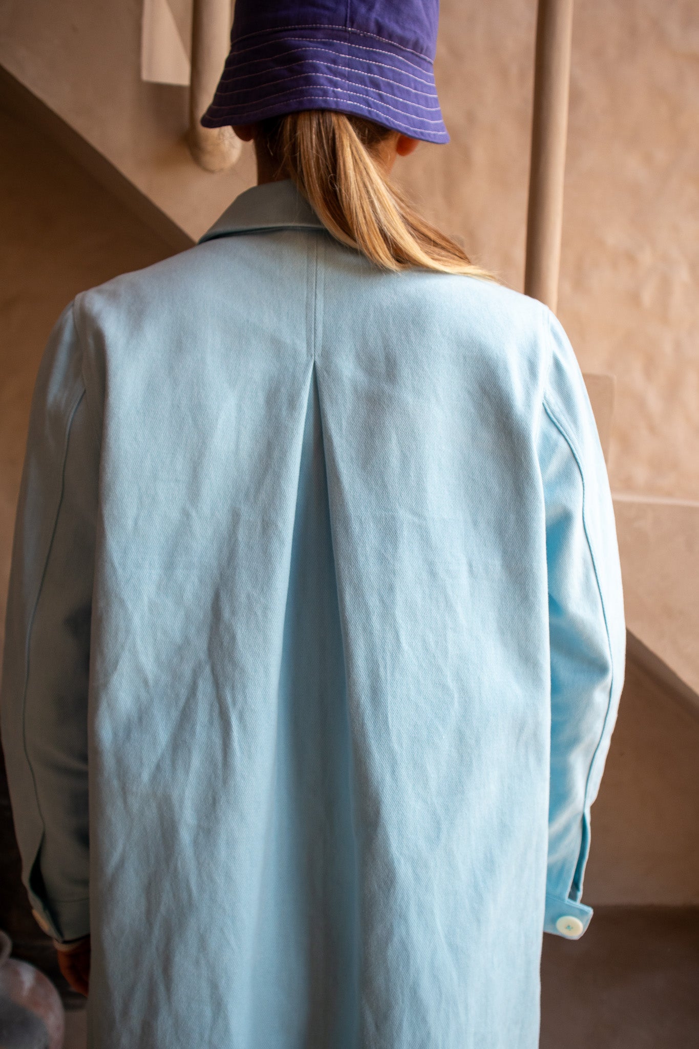 Detailed view of the back pleat and collar on the Hunter Coat in Light Sky Blue cotton twill suede.