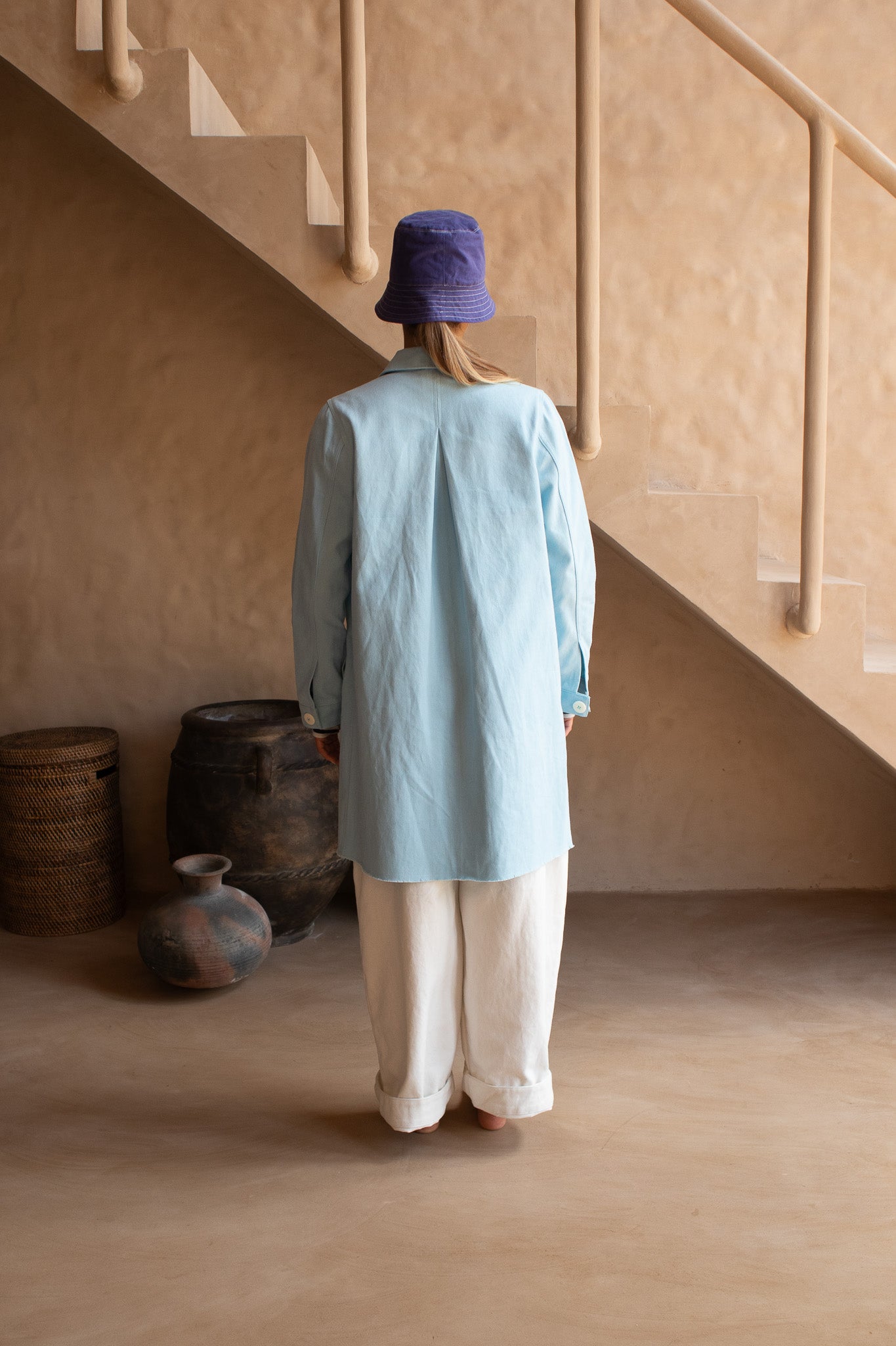 Back view of the Hunter Coat in Light Sky Blue cotton twill suede, featuring a pleat detail and relaxed fit.