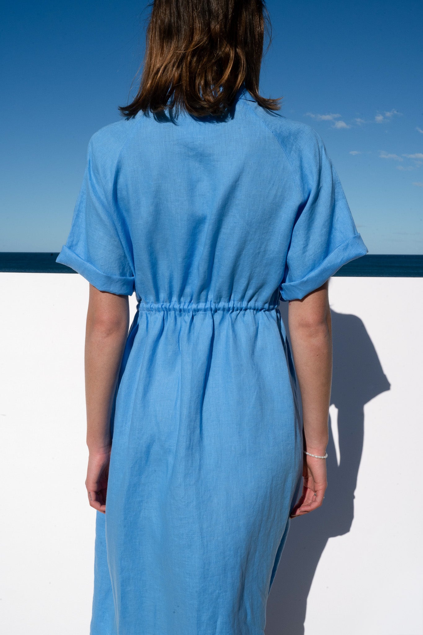 The Boy and I Iconica Dress in blue linen with white zip, close-up of back waist detail.