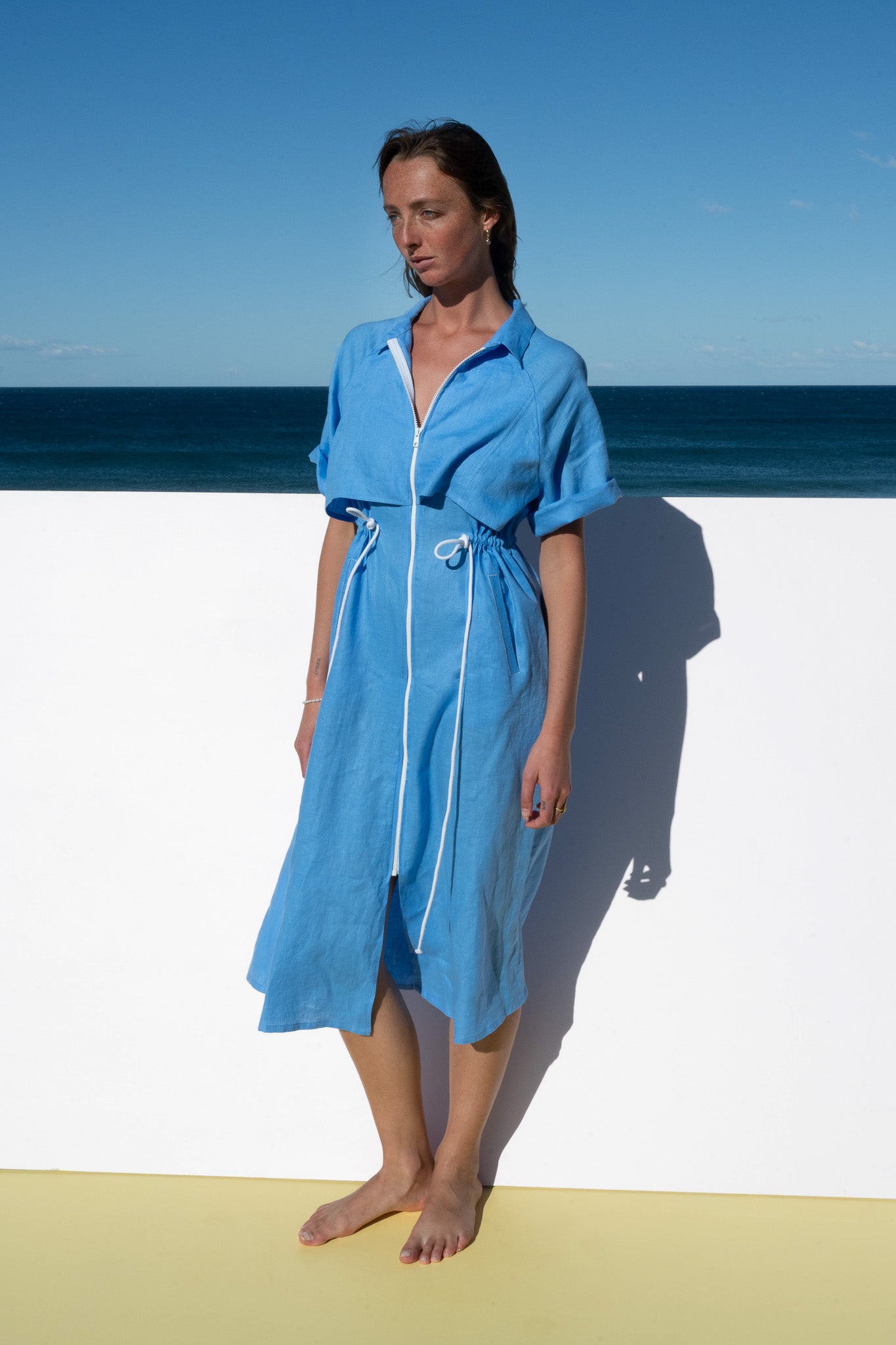Model wearing The Boy and I Iconica Dress in blue with white zip, relaxed front view.