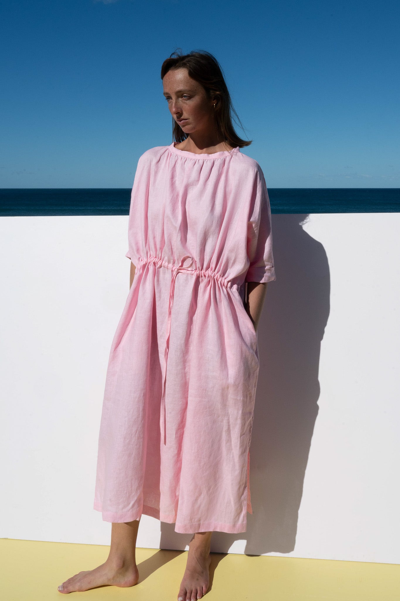 Front view of The Moments Dress in Bonbon Pink, featuring a relaxed silhouette with drawstring waist and side pockets.