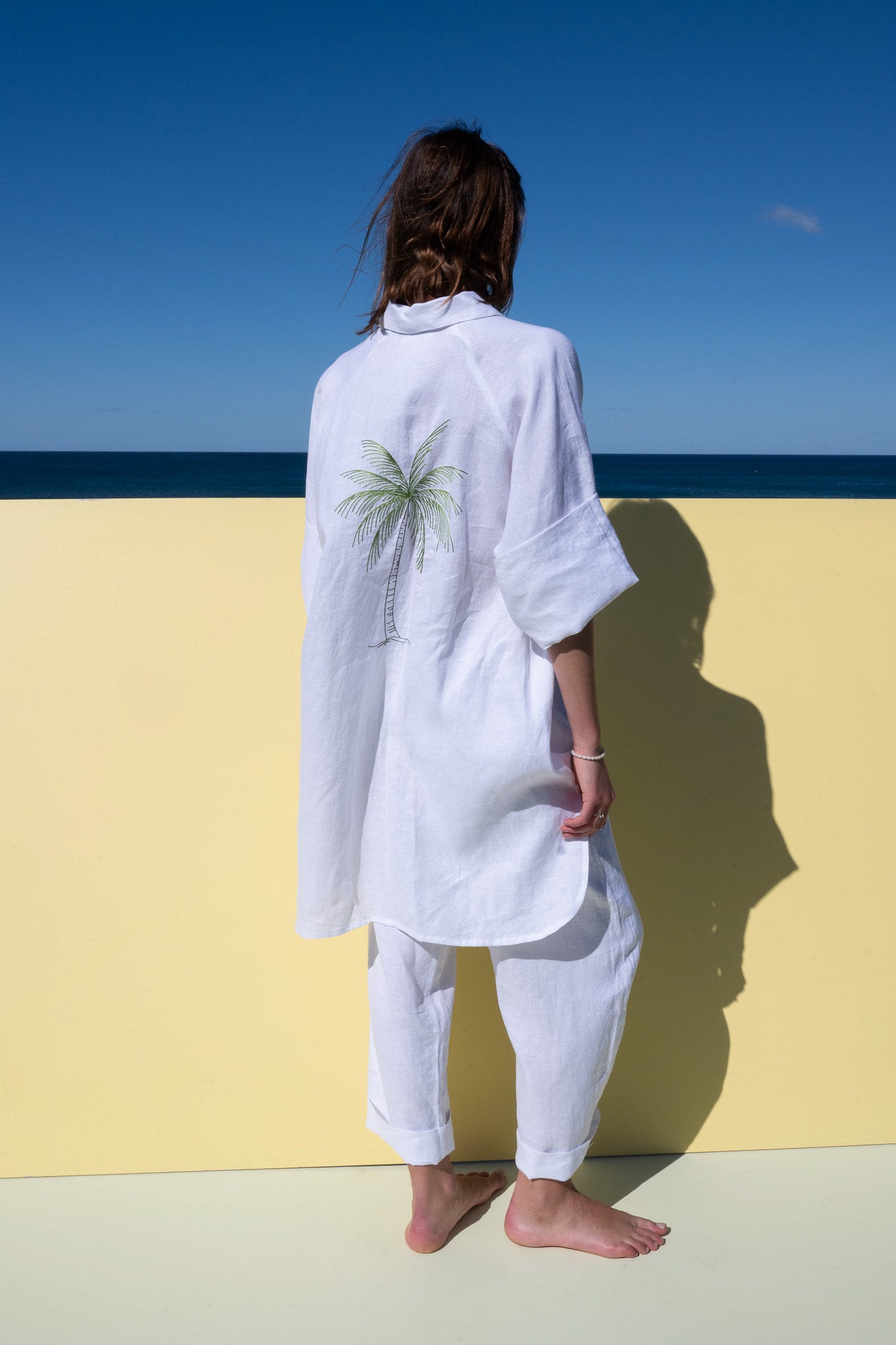 Oceanic Shirt Dress in white linen – back view with hand-drawn palm tree embroidery